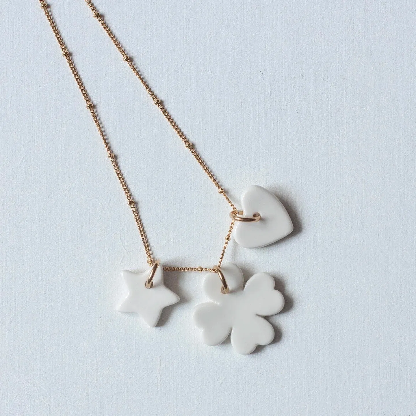 Portez la Chance à votre cou !
Grâce à ces petites amulettes de la Collection Suspendue.
Étoile, Trèfle et Cœur en porcelaine émaillée côté face et biscuit côté pile.
Montées sur chaîne fantaisie en acier inoxydable.
Hauteur Étoile : 2 cm / Hauteur Trèfle : 3 cm / Hauteur Cœur : 2 cm. Longueur Chaîne : 42 cm