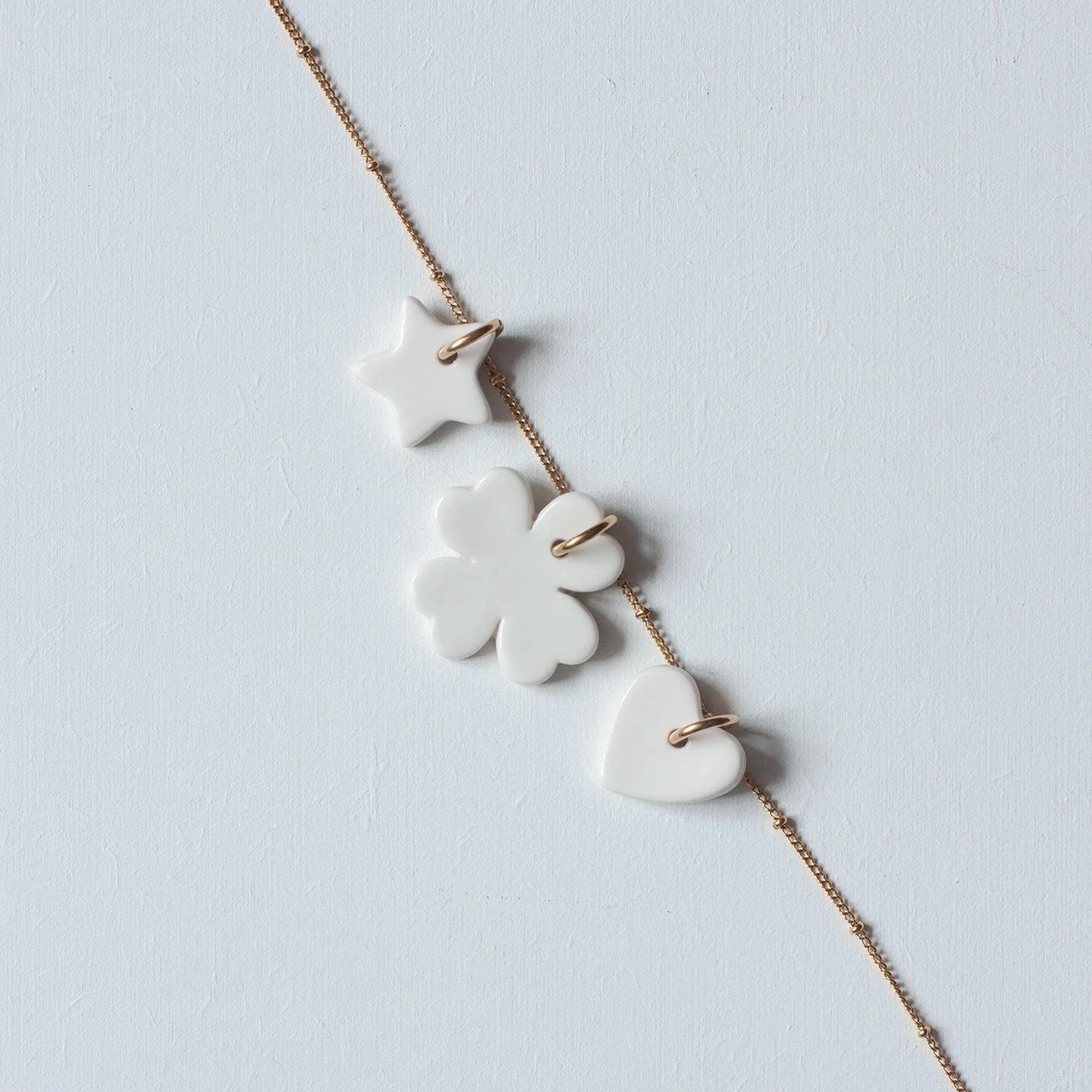 Portez la Chance à votre cou !
Grâce à ces petites amulettes de la Collection Suspendue.
Étoile, Trèfle et Cœur en porcelaine émaillée côté face et biscuit côté pile.
Montées sur chaîne fantaisie en acier inoxydable.
Hauteur Étoile : 2 cm / Hauteur Trèfle : 3 cm / Hauteur Cœur : 2 cm. Longueur Chaîne : 42 cm