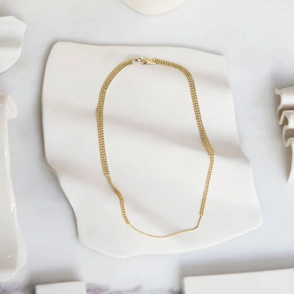 La ligne Trame s’inspire des tapisseries anciennes et des broderies précieuses. Elle rend hommage au travail minutieux et au temps long, avec des pièces ouvragées mais toujours épurées. Un jeu de composition minimal ayant pour point de départ une même trame de perles fines, travaillées comme de petites architectures tantôt géométriques, tantôt organiques. Des pièces subtiles qui captent la lumière.
Matériaux : en laiton doré à l'or fin recyclé 24 carats
Dimensions : longueur 42 cm + chaînette de réglage
Poids : 7,1g
Tous nos bijoux sont garantis 2 ans
Pensé et fabriqué main à Paris
Livré dans son packaging individuel écologique.
Conseils d'entretien : évitez le contact avec l'eau et le parfum afin que le bijou conserve son éclat
Nos matières premières sont soigneusement sélectionnées et sans risques pour votre santé : elles ne contiennent ni plomb, ni nickel, ni cadmium, conformément à la législation.