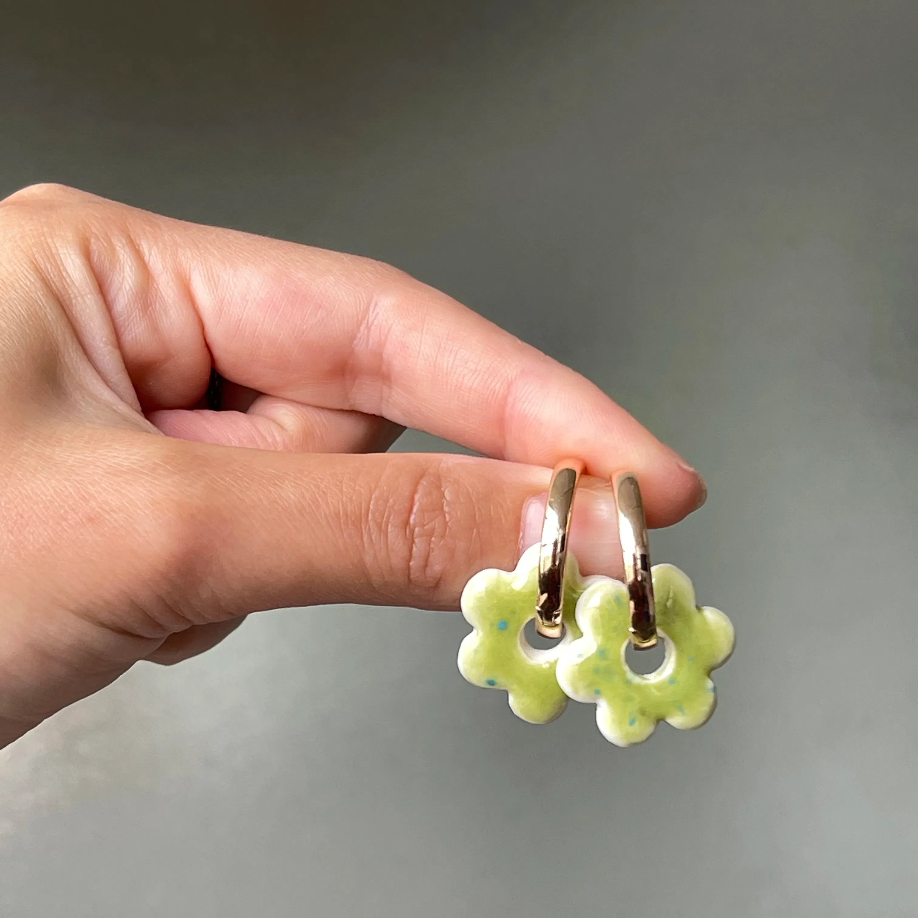 Boucles d’oreilles mini fleurs Green. Composées d’un charm en porcelaine fait à la main, et d’une créole. Elles sont toutes interchangeables, afin de varier les porcelaines sans racheter une boucle à chaque fois.