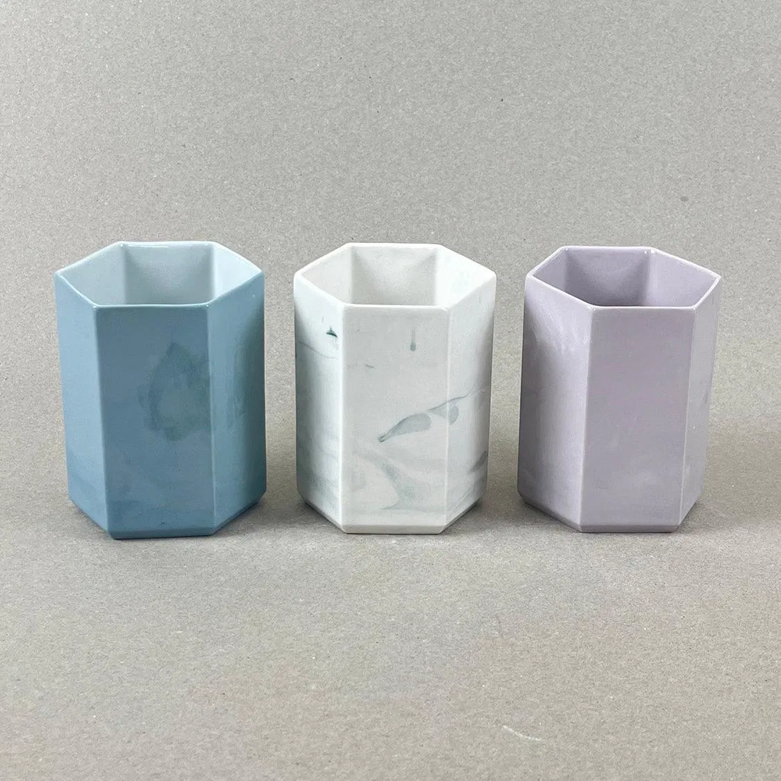 Porcelaine teintée dans la masse. Pièces à colorations variables. 8 x 12 x 8 cm. « Histoires d'eau » est un ensemble design de porcelaine contemporaine créé pour la salle de bain. Il comprend un porte-savon et un pot à brosse-à-dent. Ces délicates pièces de porcelaine allient des formes géométriques simples et des motifs organiques qui laissent rêveurs et font de chaque objet un tirage unique. Les objets de cette collection sont obtenus par coulage, un à un, à la main. L'aspect marbré qui se dessine délicatement à la surface provient de l'ajout d'une couleur directement dans la pâte de porcelaine au moment du coulage.