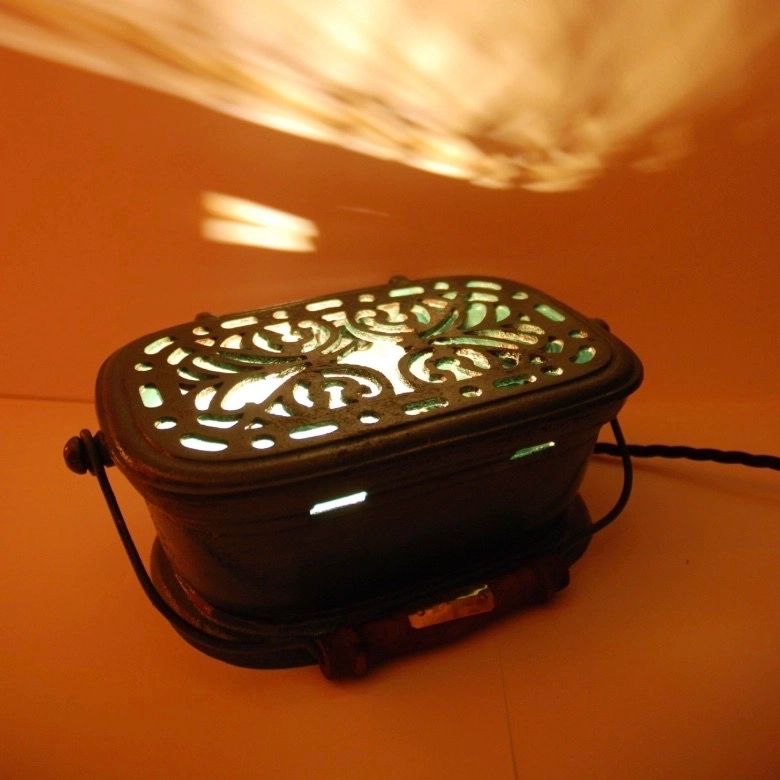 Lampe Bris de vert. Brasero en fonte.
Lumière calorique remplacée par lumière électrique.