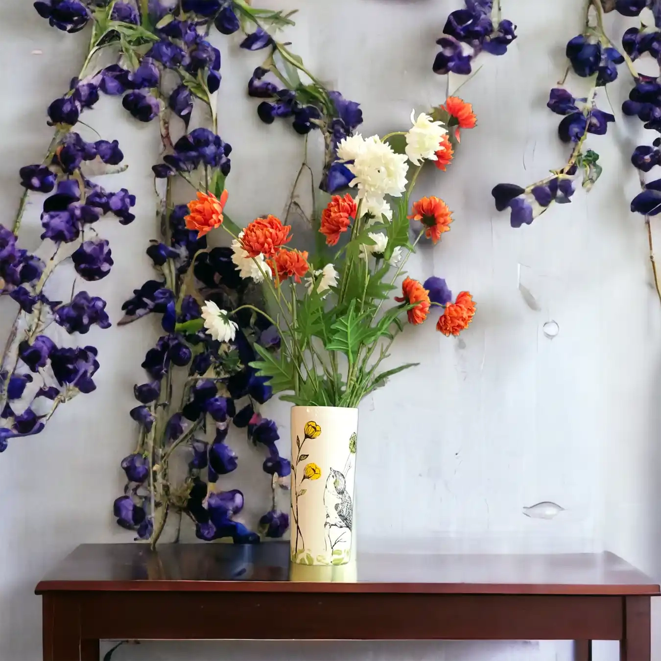 Ce vase en céramique délicatement illustré met en scène un petit oiseau posé parmi des tiges de boutons d’or lumineux.