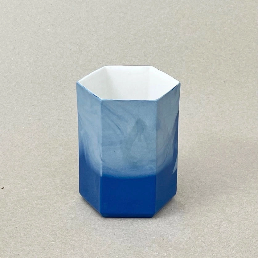 Porcelaine teintée dans la masse. Pièces à colorations variables. 8 x 12 x 8 cm. « Histoires d'eau » est un ensemble design de porcelaine contemporaine créé pour la salle de bain. Il comprend un porte-savon et un pot à brosse-à-dent. Ces délicates pièces de porcelaine allient des formes géométriques simples et des motifs organiques qui laissent rêveurs et font de chaque objet un tirage unique. Les objets de cette collection sont obtenus par coulage, un à un, à la main. L'aspect marbré qui se dessine délicatement à la surface provient de l'ajout d'une couleur directement dans la pâte de porcelaine au moment du coulage.