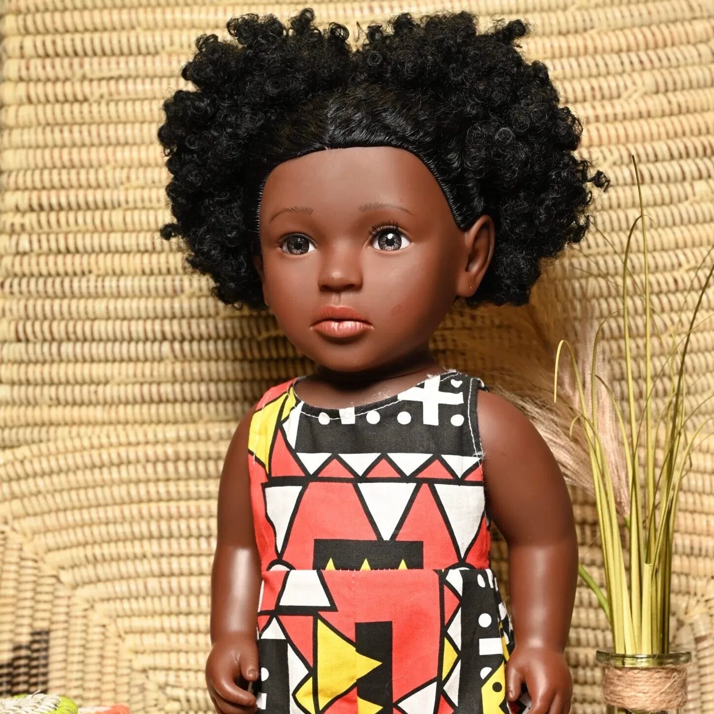 Poupée noire « Linguère Dégueune Mbaye » a des cheveux noirs bouclés. Cette poupée représente l’identité d’une petite fille métisse. Elle porte une combinaison en Wax dont la couleur dominante est le rose