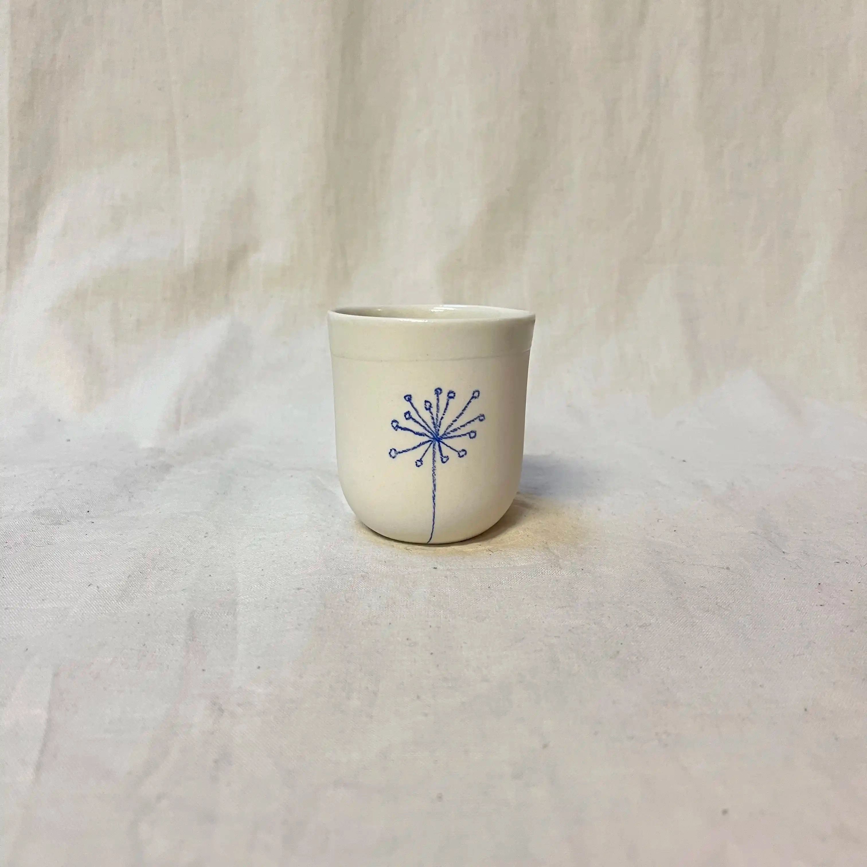 Tasse porcelaine moulée. Diamètre 6,5cm, hauteur 7 cm. Émail intérieur, décor au crayon à oxydes