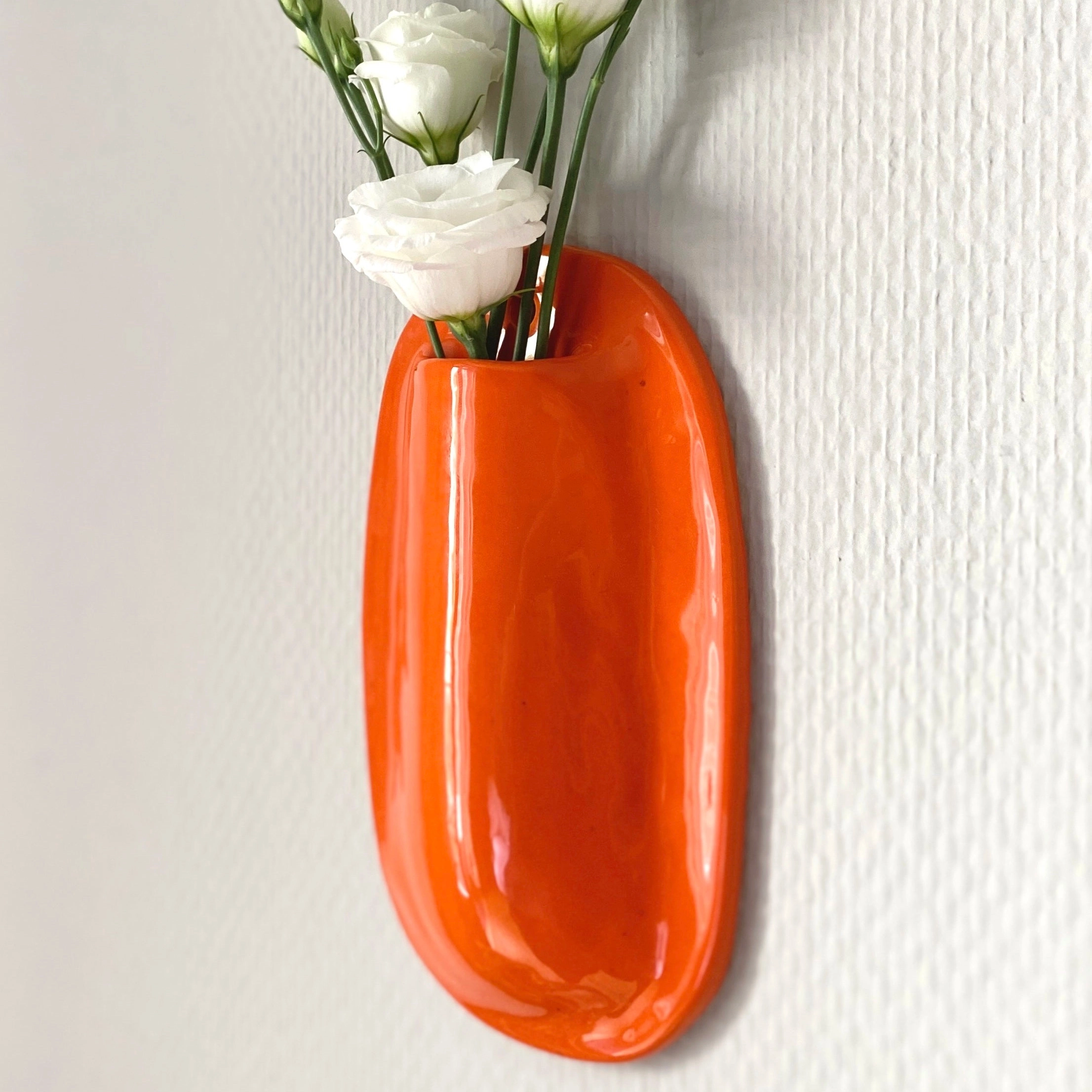 Vase mural en faience, fabriqué à la main à Paris. Émaille orange brillant. Environ 18x11x3 cm. Dispo sur commande dans la couleur de votre choix. CAP Céramique Artisanale Parisienne.