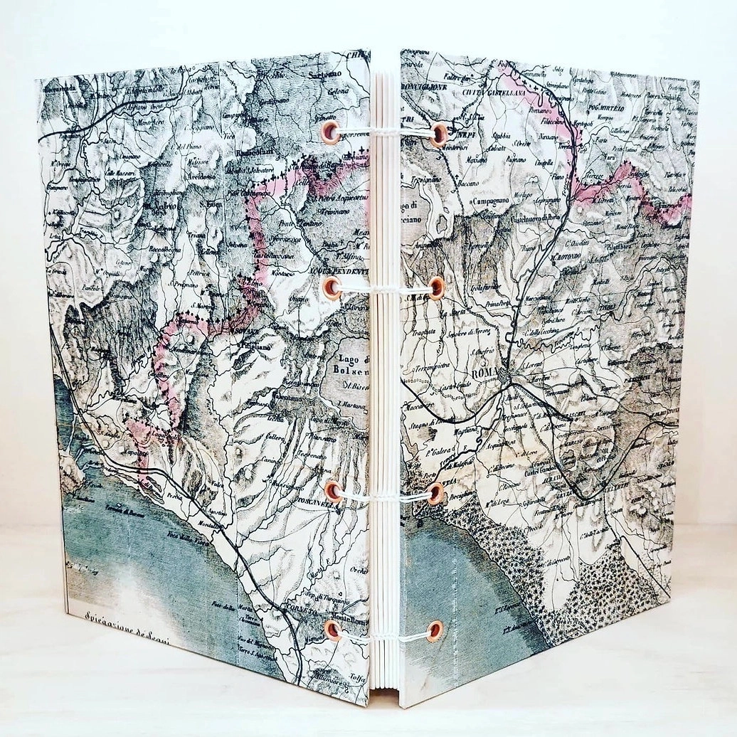 Carnet de voyage - Modèle unique - Format A5
Couverture rigide, carte vintage de la province de Rome, Italie (1875). 140 pages blanches (100g) pour écrire ou dessiner.
Reliure copte entièrement cousue à la main, permettant une ouverture à plat du carnet.