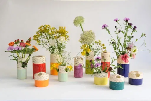 Ce vase en céramique allie élégance et fantaisie avec sa base d'un vert pastel doux et son col orné de petits pois noirs sur fond blanc. Sa forme élancée met en valeur tous types de bouquets, des plus champêtres aux plus sophistiqués.