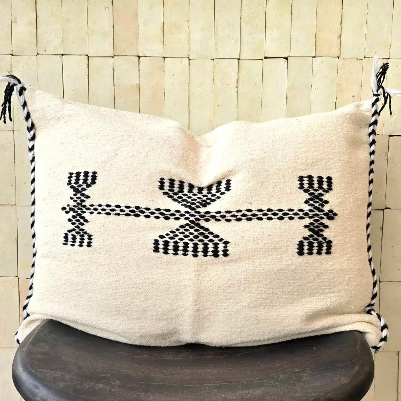 Cette grande housse de coussin noire et blanche tissée main vient de Tlemcen, ville d’Algérie connue pour la qualité de son artisanat textile. Elle combine un tissage en laine blanc cassé sur une trame fine de coton, et des motifs noirs hérités des traditions de la région.
Ce coussin s’intégrera aussi bien à un intérieur contemporain qu’à une décoration épurée, bohème ou classique. Apportez une dimension culturelle authentique et originale grâce à ces housses de coussin, que ce soit sur un canapé ou un fauteuil dans votre salon, ou dans une chambre sur votre lit
Fabriqué à partir de matériaux locaux et durables, ce coussin noire et blanche de Tlemcen est plus qu’un simple objet déco: il raconte l’histoire des femmes et des hommes qui perpétuent un artisanat riche et précieux. Offrez à votre intérieur une pièce unique qui incarne un mélange parfait entre traditions et design.
N’hésitez pas à mixer les couleurs, les tailles ainsi que les matières pour une décoration qui vous ressemble, et insuffler un esprit unique à votre intérieur
Dimensions 65 x 48 cm environ