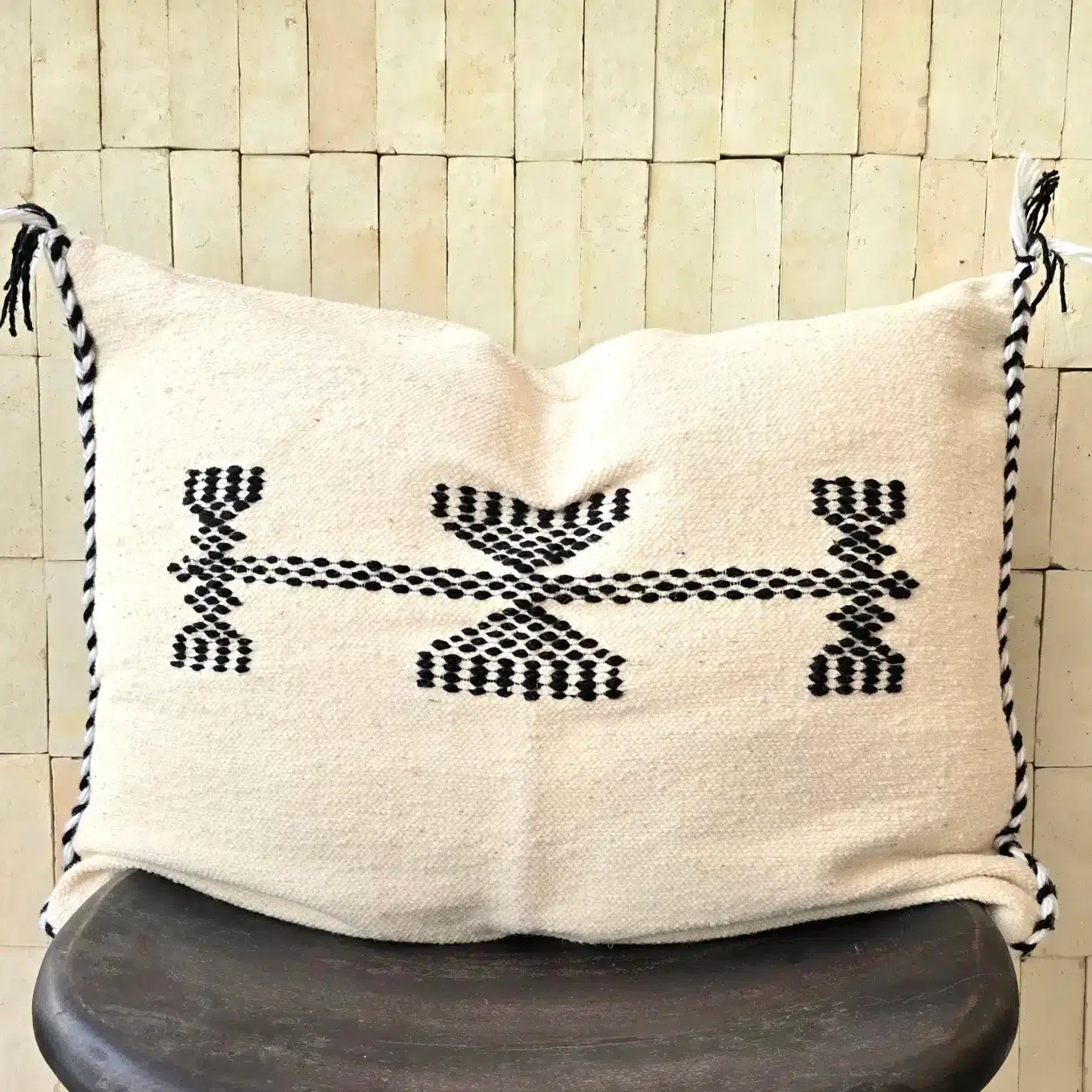 Cette grande housse de coussin noire et blanche tissée main vient de Tlemcen, ville d’Algérie connue pour la qualité de son artisanat textile. Elle combine un tissage en laine blanc cassé sur une trame fine de coton, et des motifs noirs hérités des traditions de la région.
Ce coussin s’intégrera aussi bien à un intérieur contemporain qu’à une décoration épurée, bohème ou classique. Apportez une dimension culturelle authentique et originale grâce à ces housses de coussin, que ce soit sur un canapé ou un fauteuil dans votre salon, ou dans une chambre sur votre lit
Fabriqué à partir de matériaux locaux et durables, ce coussin noire et blanche de Tlemcen est plus qu’un simple objet déco: il raconte l’histoire des femmes et des hommes qui perpétuent un artisanat riche et précieux. Offrez à votre intérieur une pièce unique qui incarne un mélange parfait entre traditions et design.
N’hésitez pas à mixer les couleurs, les tailles ainsi que les matières pour une décoration qui vous ressemble, et insuffler un esprit unique à votre intérieur
Dimensions 65 x 48 cm environ