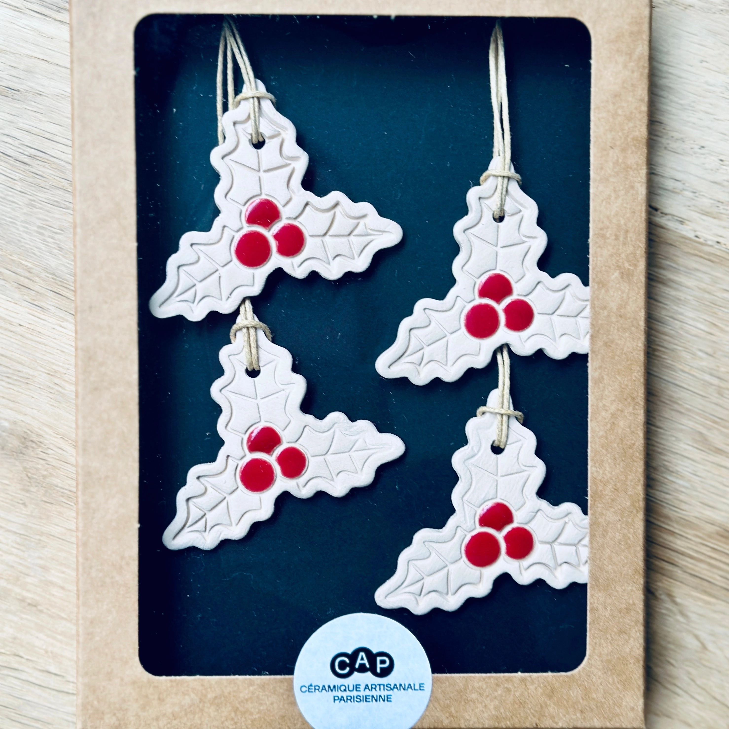 4 Pendentifs Houx pour sapin de Noël. Fabriqués à la main en faïence, à Paris. Environ 5x4,5 cm. Ficelle résistante en coton ciré. CAP Céramique Artisanale Parisienne