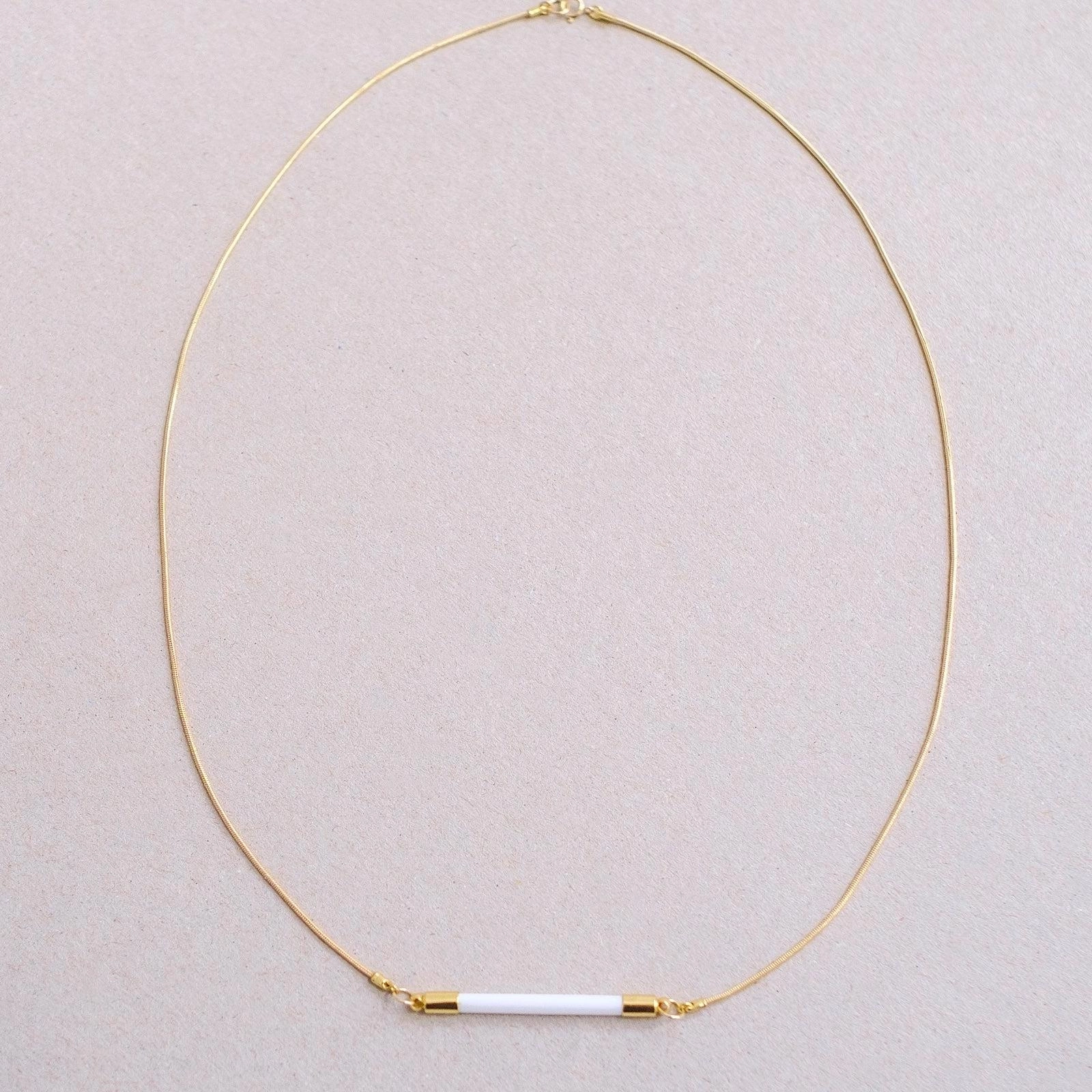 Cylindre de porcelaine taillé à la main, apprêts dorés à l’or fin. Longueur : 57 cm Télégraphe est une collection de bijoux élégante et épurée, qui se porte aussi bien en soirée que dans un quotidien actif. Discrète, elle souligne la délicatesse des traits de celle -ou celui- qui en porte les pièces. Les éléments en porcelaine de cette collection sont tous taillés au diamant, un par un, dans un bloc brut. A travers cette manière de faire, très inhabituelle pour la porcelaine, Eugène Griotte imite les gestes du lapidaire.