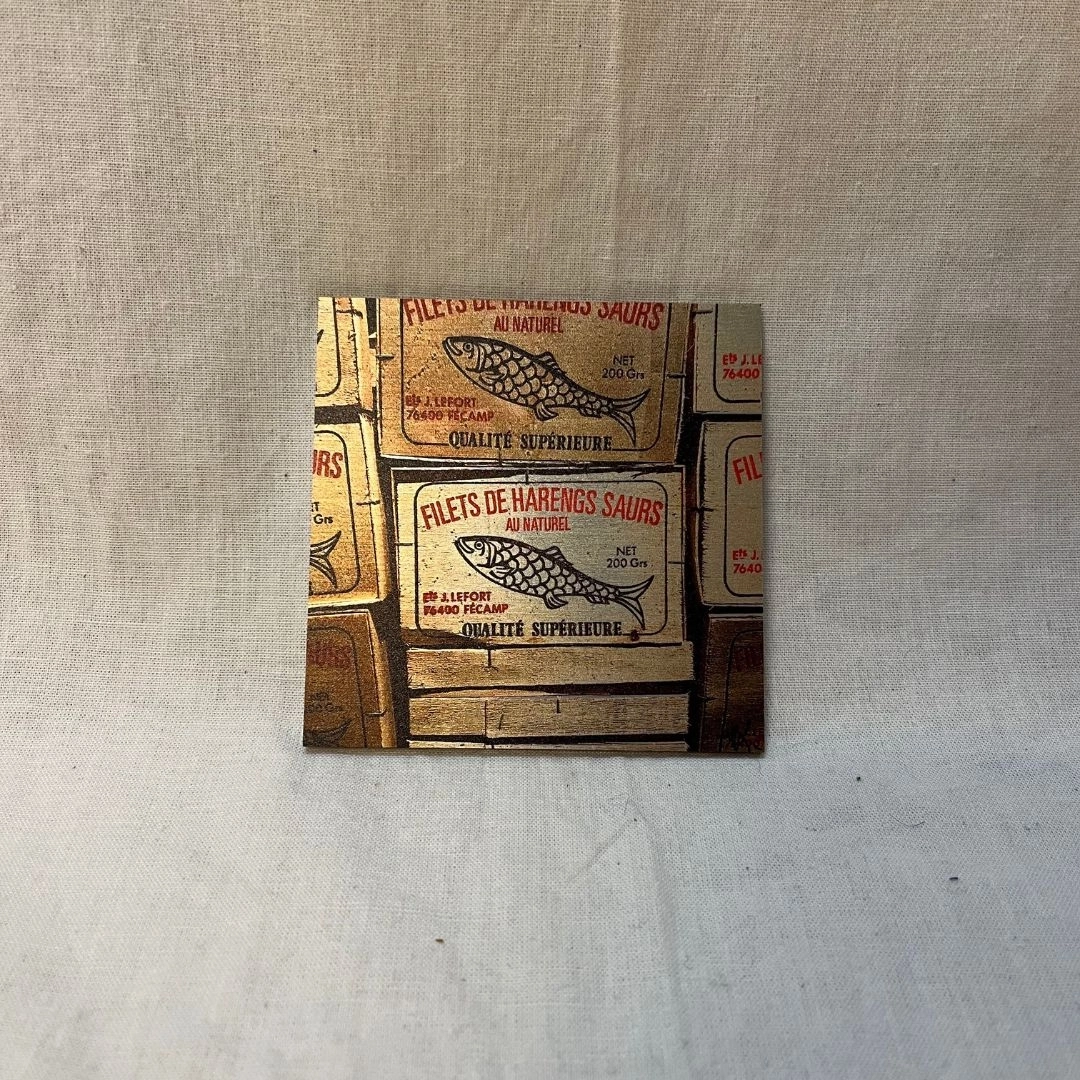 Les harengs (9x9) Vieilles boîtes de harengs du XIXe siècle photographiées dans un musée à Fécamp, capturant un charme décalé et souvent ignoré.