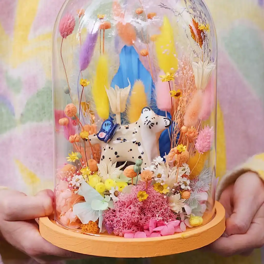 Une grande cloche de fleurs séchées qui abrite un léopard et un papillon en faïence réalisé par la céramiste Dodo Toucan.
La figurine est modelée et peinte à la main dans leur atelier parisien, chaque duo léopard / papillon est unique.
Dimensions : Cloche : ø 17 cm x H 24 cm. Léopard papillon en faïence : environ 9 cm