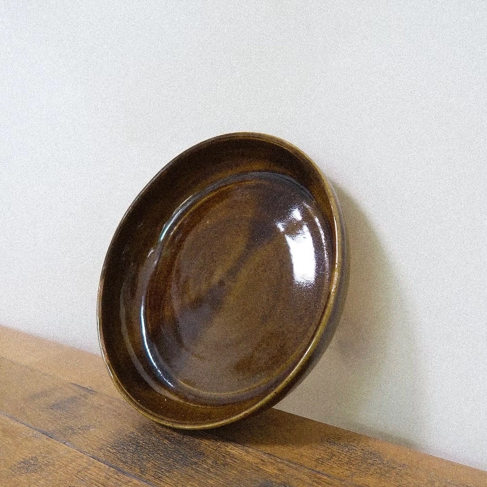 Une pièce singulière, pensée pour embellir les gestes simples du quotidien.
Tournée à la main et recouverte d’un émail brun aux reflets miels, cette assiette révèle des nuances douces et subtiles qui évoluent selon la lumière. Sa forme légèrement irrégulière porte la trace du façonnage manuel, rendant chaque pièce unique.
Pensée pour accueillir un repas, une part de gâteau ou quelques fruits, elle invite à ralentir et à savourer, en ajoutant une touche sensible et chaleureuse à votre table.
Chaque assiette est réalisée à la main dans mon atelier à Paris.
DIMENSIONS : Ø 18,5cm environ
