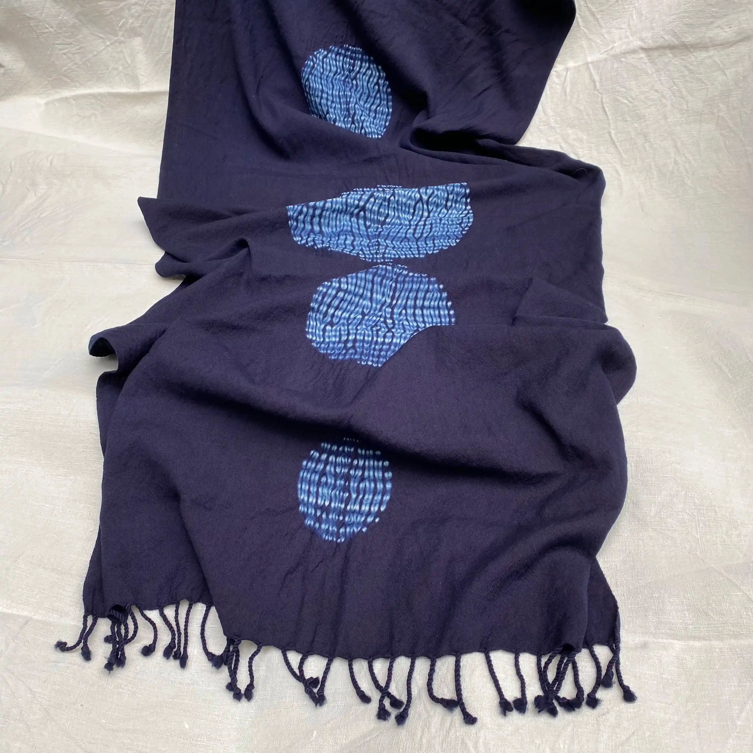 Écharpe en mérinos teinte à l’indigo avec la technique shibori "mokume", produisant des motifs torsadés