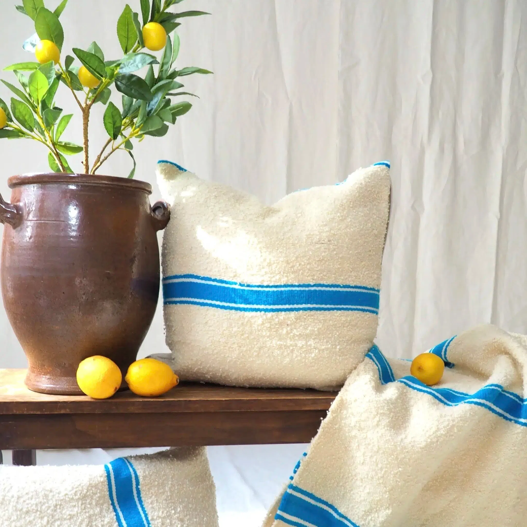 Coussin Berbère rayé blanc cassé et bleu. Housse confectionnée à partir de couvertures traditionnelles en laine bouclette.
Les femmes s’en servent à l’origine pour se couvrir et se tenir chaud. Elles les tissent à la main sur des métiers à tisser traditionnels, et se transmettent ce savoir faire artisanal précieux de génération en génération. Le fond est généralement écru ou blanc cassé. Les rayures sont des motifs classiques, les couleurs varient.
Disposez ces coussins aussi bien dans votre salon que votre chambre! Grâce à leur style épuré, elles s’intègrent à tous les styles de décoration d’intérieur. Faites entrer le soleil chez vous et ajoutez instantanément une touche méditerranéenne à votre pièce! N’hésitez pas à marier les motifs et couleurs pour un rendu unique et bohème.
Dimensions: elles mesurent 50 x 50 cm environ et disposent d’une fermeture éclair