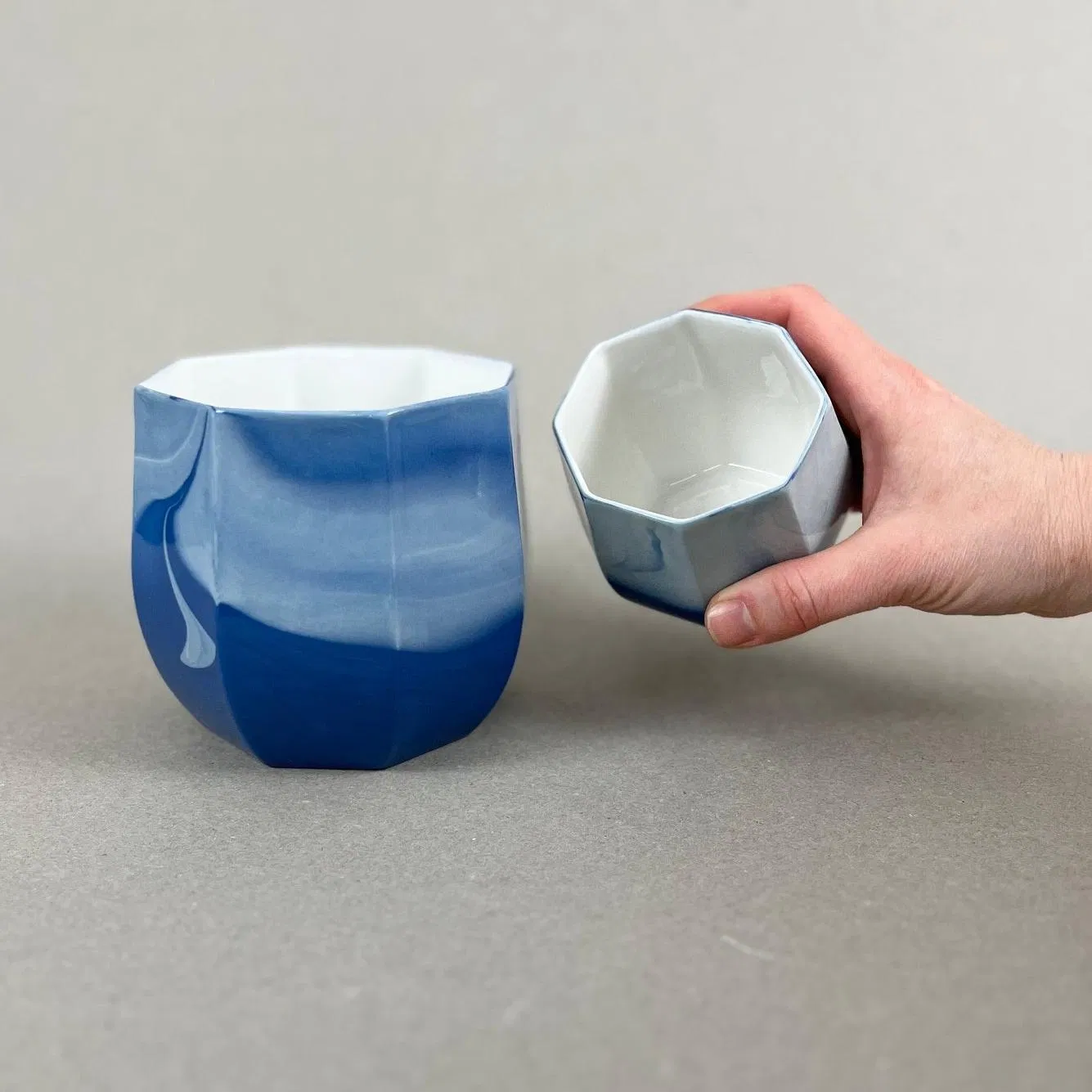 Porcelaine teintée dans la masse. Pièces à colorations variables. 12 x 12 x 11 cm. Ino, protectrice des marins et des naufragés, déesse des mers calmes. Une idée apaisante qu'il est rassurant d'avoir chez soi. Ce cache-pot aux allures de petit tonneau semble pouvoir résister aux tempêtes, et hébergera certainement nos plantes préférées, celles qu'on emmènera en toutes circonstances. Les pièces sont obtenues par coulage, une à une, à la main. Le précipité de couleur rend chaque pièce unique.