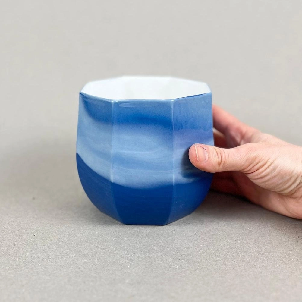 Porcelaine teintée dans la masse. Pièces à colorations variables. 12 x 12 x 11 cm. Ino, protectrice des marins et des naufragés, déesse des mers calmes. Une idée apaisante qu'il est rassurant d'avoir chez soi. Ce cache-pot aux allures de petit tonneau semble pouvoir résister aux tempêtes, et hébergera certainement nos plantes préférées, celles qu'on emmènera en toutes circonstances. Les pièces sont obtenues par coulage, une à une, à la main. Le précipité de couleur rend chaque pièce unique.