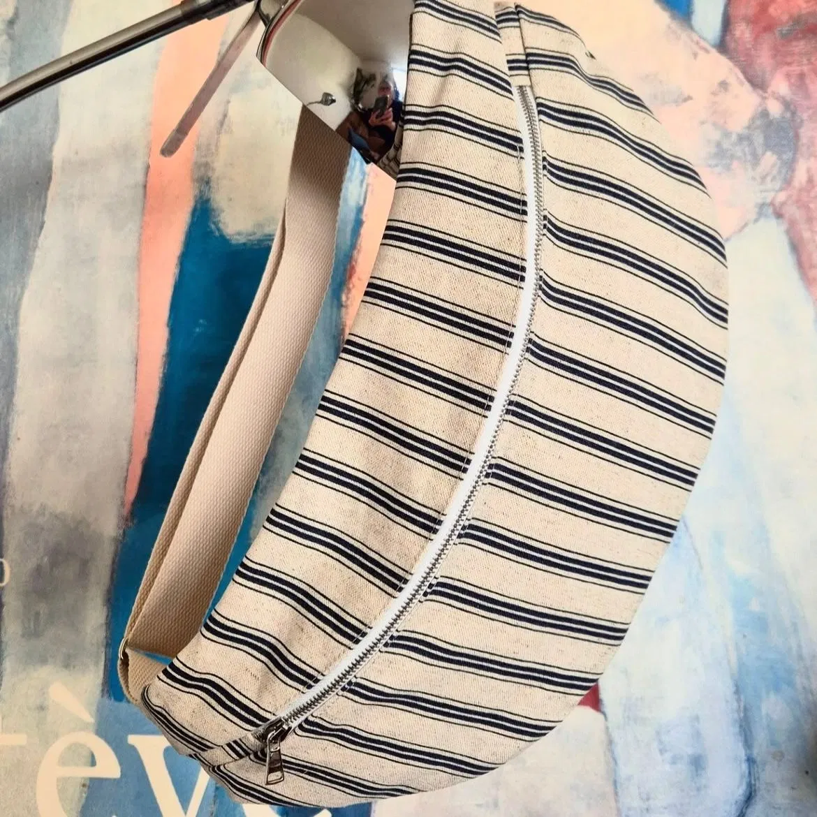 Sac-banane en toile de coton. Doublure coton imprimé. Elle est équipée d’une double poche intérieure et d’une sangle coton réglable.