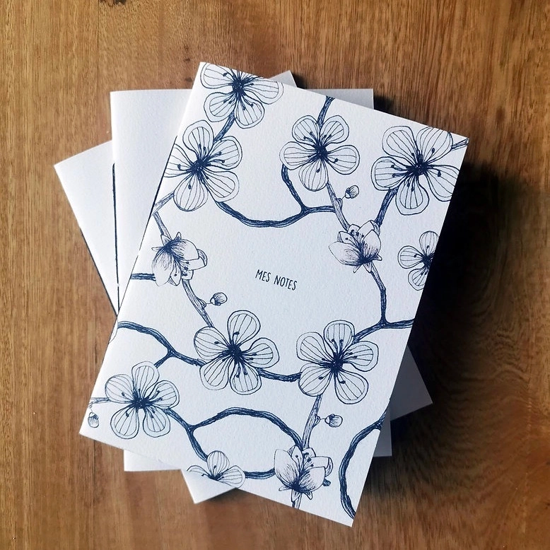 Un petit carnet à toujours avoir dans son sac.
Carnet comprenant 40 pages vierges, reliure cousue au fil noir, couverture souple imprimée avec llustration originale.
Trois motifs disponibles : Mandala "mes notes", Fleurs de cerisiers "mes notes", Poissons "Toutes les idées sont bonnes à prendre".
Format A6