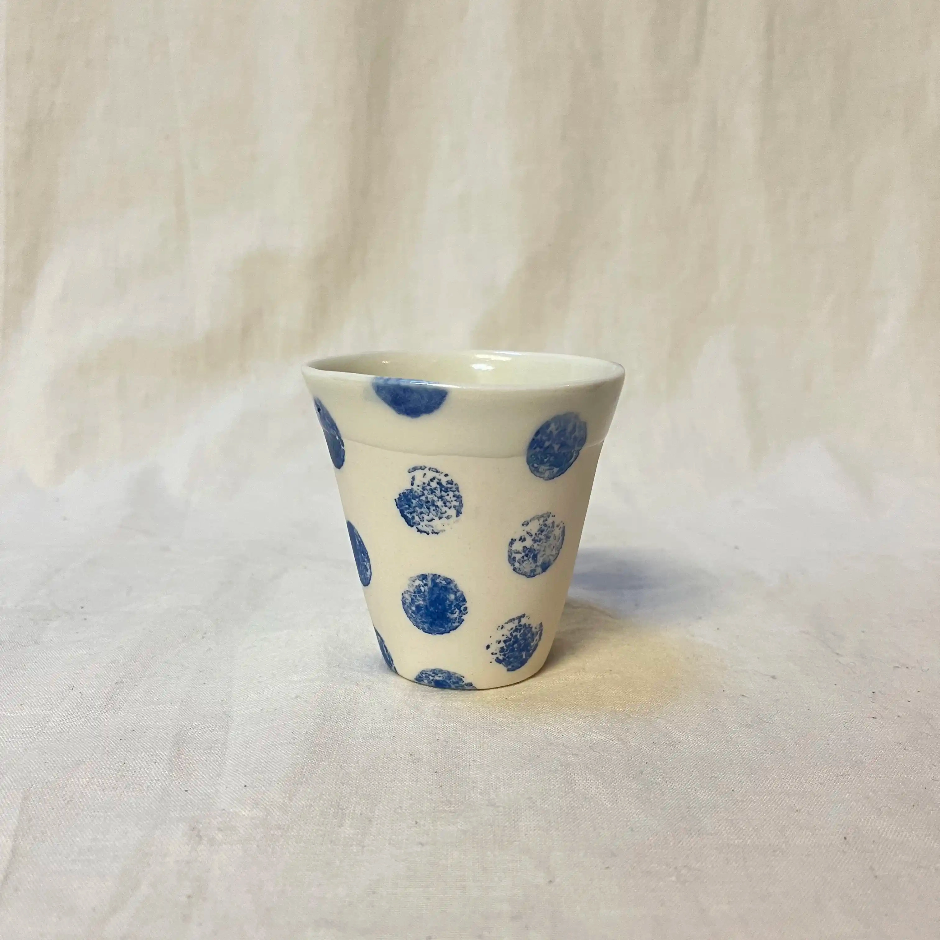 Tasse en porcelaine moulée. Diamètre 8 cm, hauteur 8,5cm. Décor à l’engobe