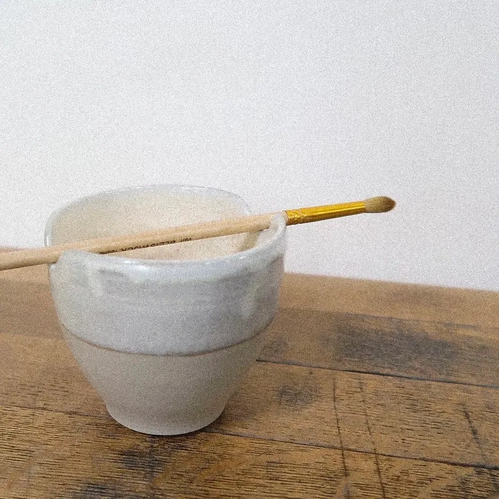 Tourné à la main dans mon atelier parisien, ce repose pinceau est pensé pour les gestes lents, les instants créatifs et les pratiques qui demandent attention. Deux encoches permettent de poser son pinceau avec soin, entre deux touches d’aquarelle, d’encre ou de gouache.
L’émail blanc nacré offre une surface lisse et lumineuse, légèrement irisée selon la lumière, il évoque la douceur d’un coquillage.
Chaque pièce est réalisée à la main à Paris. Formes, couleurs et textures peuvent donc présenter de légères variations : autant de petites singularités qui rendent chaque objet unique.
DIMENSIONS : Ø 9cm, H 4cm environ.
Les pièces sont uniques et peuvent présenter de légères variation de forme, de taille ou de couleur.