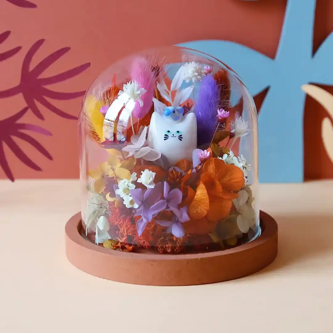 Une petite cloche de fleurs séchées qui abrite un chat pinson en faïence réalisé par la céramiste Dodo Toucan.
La figurine est modelée et peinte à la main dans leur atelier parisien, chaque duo chat.
Dimensions : Cloche : ø 12 cm x H 12 cm. Chat pinson en faïence : environ 3,5 cm