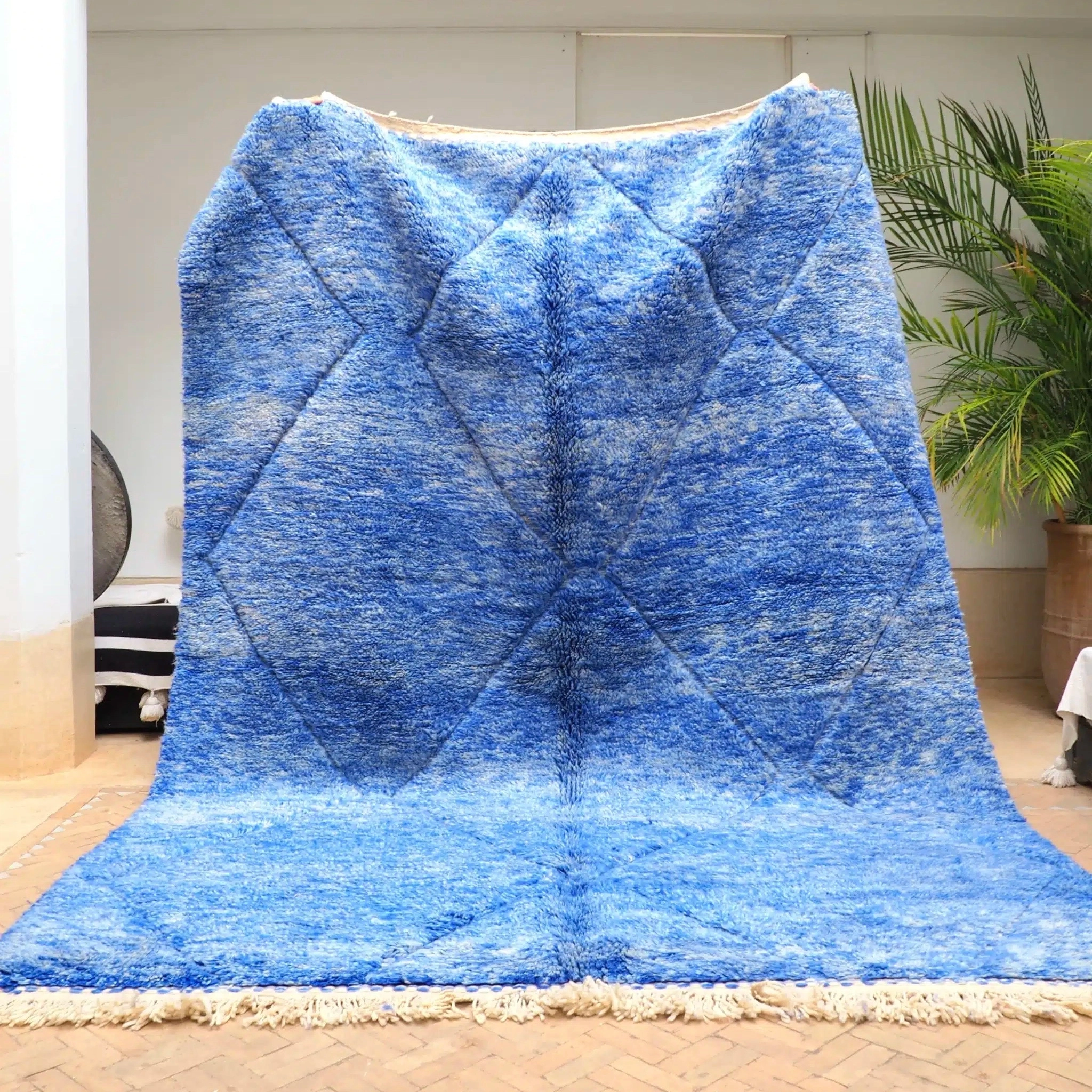 Grand tapis Berbère Marocain Mrirt aux nuances de bleu moucheté blanc cassé et motifs graphiques en relief, création exclusive pour Les Possibles Shop.
Tissé à la main dans le Moyen Atlas, le M’rirt est tissé à partir de la plus belle laine de mouton du Maroc. C’est une laine d’excellente qualité, les tapis sont très denses grâce à ses doubles nœuds.
Votre tapis vous offrira une épaisseur et un moelleux sans pareils, qui vous accompagnera de nombreuses années. C’est une véritable merveille qui apportera caractère et chaleur à votre intérieur. Il trouvera sa place aussi bien dans votre chambre que votre salon ou salle à manger.
C’est un tapis entièrement réalisé à la main et d’une qualité exceptionnelle, c’est une pièce unique et luxueuse
Dimensions: Il mesure 300 x 210 cm environ