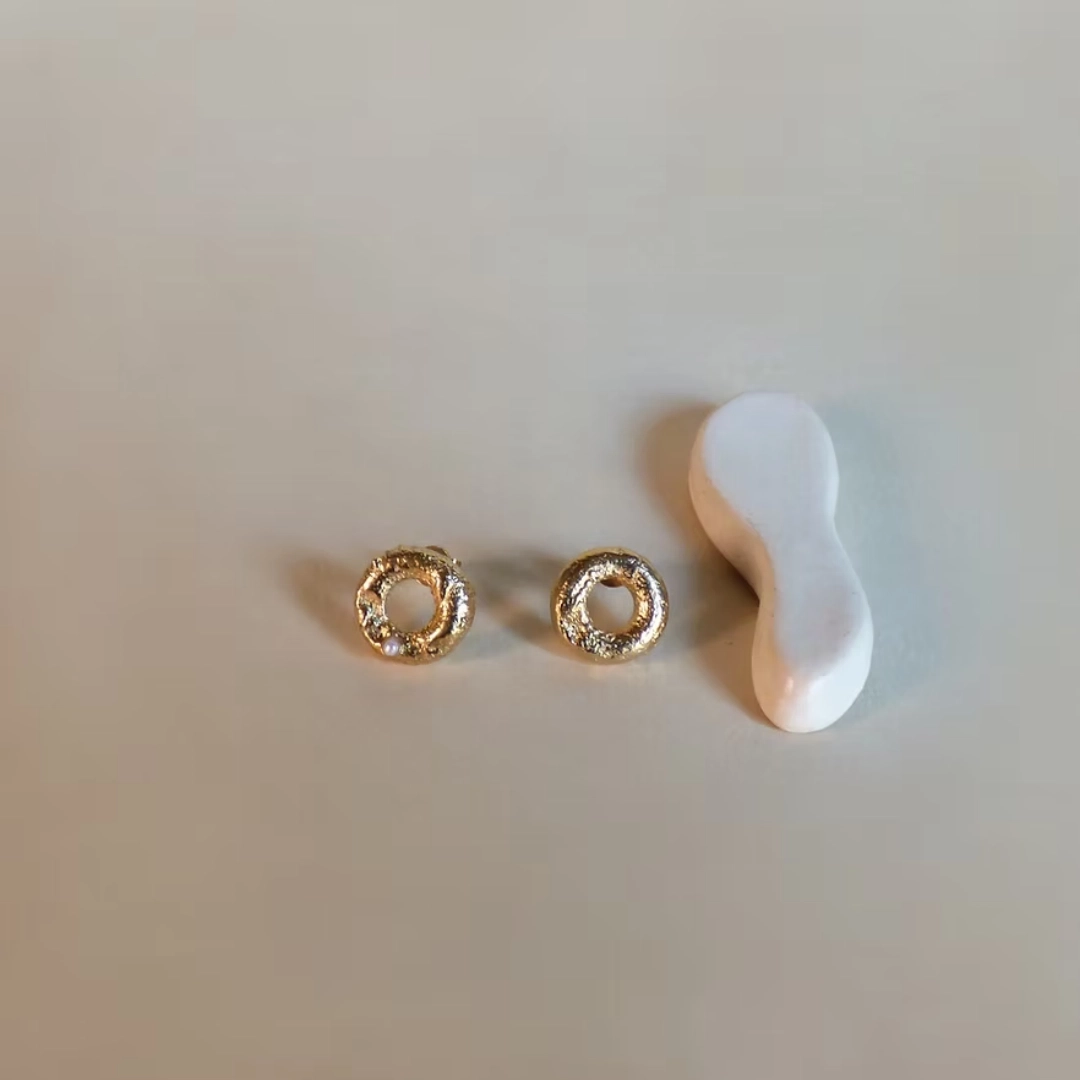 Les puces NUBIA sont deux cercles épais qui viennent se poser sur le lobe. Leur texture unique et irrégulière en font tout leur charme. Ce bijou a été fabriqué à partir de perles de métal africaines, dont la texture varie d'une pièce à l'autre. Légèrement asymétrique, vous trouverez d'un côté une petite pierre.
Les bijoux Atelier Nicol sont entièrement fabriqués en laiton (sans nickel, non allergène), puis recouverts d'un bain d'or. Le placage trois microns permet à chaque pièce de pouvoir vous accompagner au quotidien et de durer dans le temps. Les bijoux plaqué argent sont, quant à eux, recouvert d'un bain d'argent de dix microns.