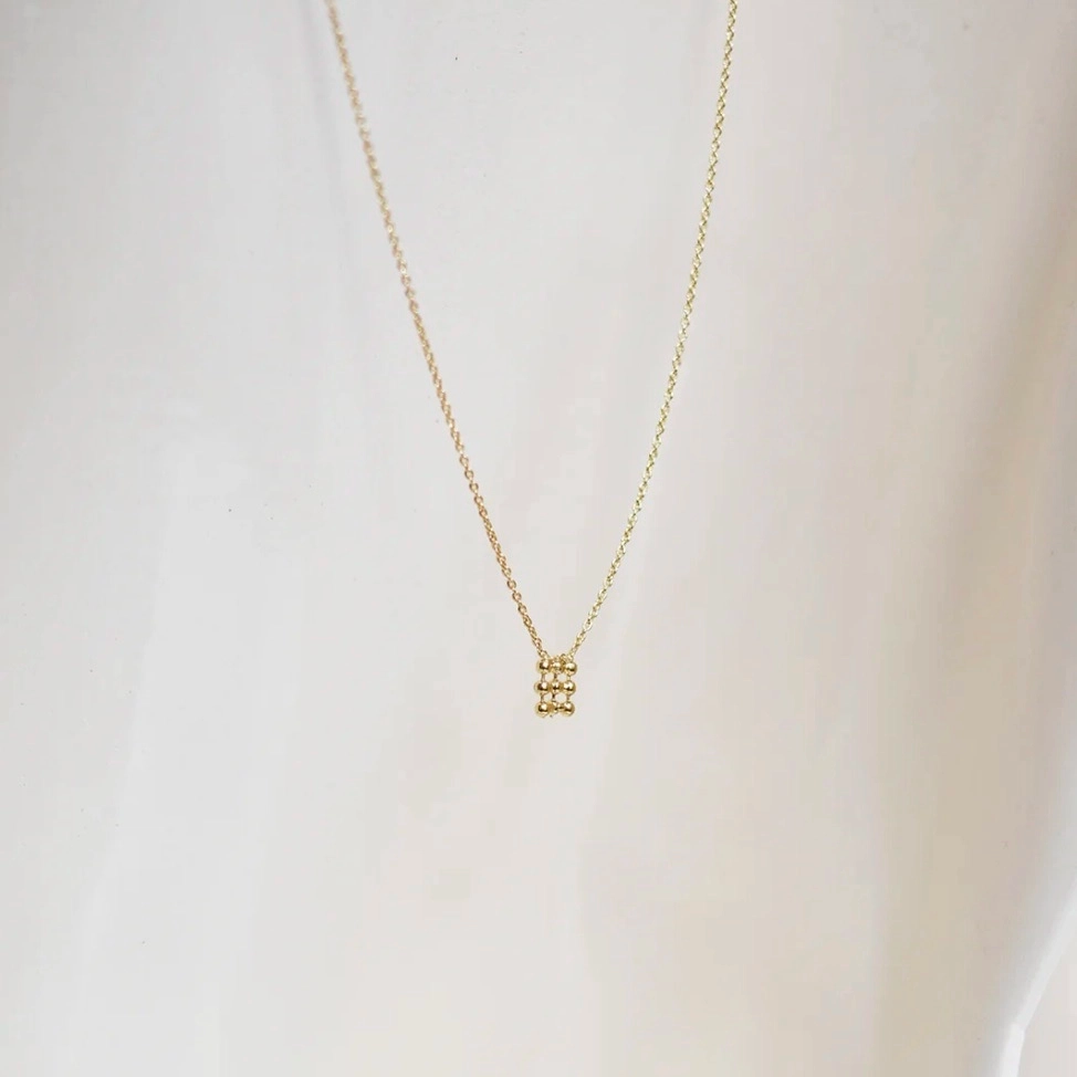 La ligne Trame s’inspire des tapisseries anciennes et des broderies précieuses. Elle rend hommage au travail minutieux et au temps long, avec des pièces ouvragées mais toujours épurées. Un jeu de composition minimal ayant pour point de départ une même trame de perles fines, travaillées comme de petites architectures tantôt géométriques, tantôt organiques. Des pièces subtiles qui captent la lumière.
Matériaux : laiton doré à l'or fin recyclé 24 carats, couleur laquée
Dimensions : longueur 42 cm + chaînette de réglage
Poids : 1,49g
Tous nos bijoux sont garantis 2 ans
Pensé et fabriqué main à Paris
Livré dans son packaging individuel écologique.
Conseils d'entretien : évitez le contact avec l'eau et le parfum afin que le bijou conserve son éclat
Nos matières premières sont soigneusement sélectionnées et sans risques pour votre santé : elles ne contiennent ni plomb, ni nickel, ni cadmium, conformément à la législation.