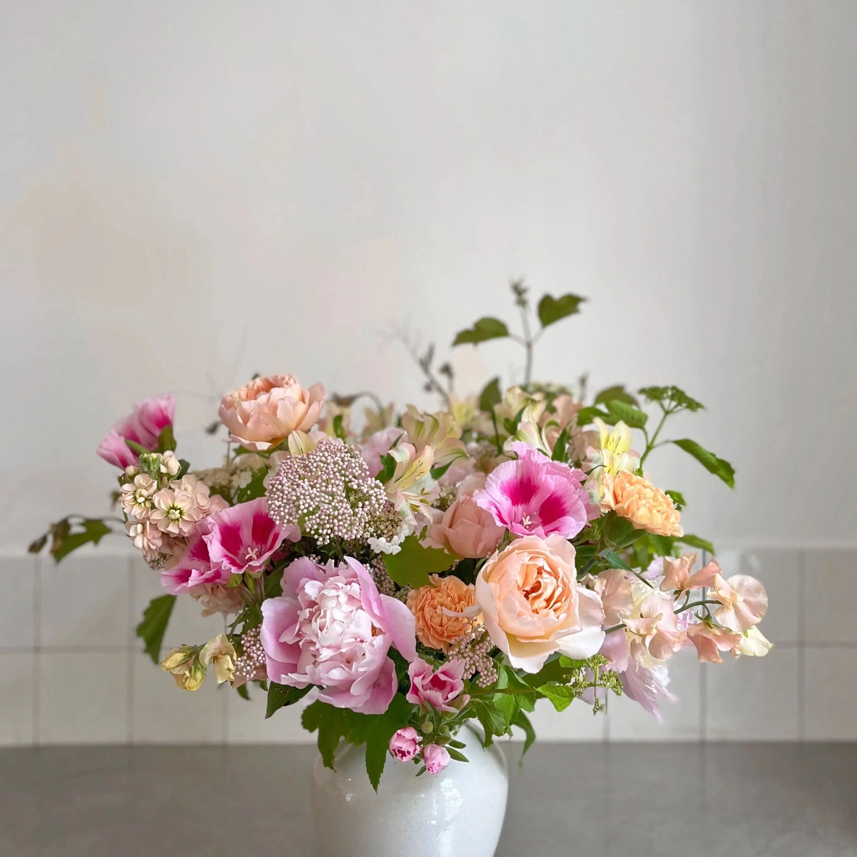 Pour le moment, Désirée livre exclusivement Paris intra-muros et la banlieue limitrophe. Une livraison 100% garantie Une livraison aux petits oignons, ça ne s'improvise pas : chez Désirée, les destinataires sont systématiquement contactés (mais sans dire qu'ils vont recevoir un bouquet ni bien sûr de qui ça vient) pour nous assurer de leur présence et éviter les échecs de livraison. Vous avez une demande spécifique (couleurs, détails de livraison) ? Dites-nous tout dans le champ "commentaires" de la page panier ! Tous vos petits mots sont écrits à la main par de vrais humains, et nous mettons un point d'honneur à réaliser le bouquet de vos rêves en fonction des occasions ! Une composition de saison sur mesure Cet ensemble se compose d'un vase artisanal fabriqué à la main au Portugal et d'un bouquet de fleurs locales et de saison réalisé selon l'inspiration du jour par nos fleuristes. Ensemble, le bouquet et le vase mesurent environ 50cm de hauteur. Envie de couleurs en particuliers? Optez pour le pastel si vous aimez les teintes douces. Si vous préférez les couleurs franches et prononcées, choisissez plutôt l'option couleurs vives. Pas d'avis? Faites nous confiance, on adore vous surprendre ! Conçu pour se marier avec tous les intérieurs, l e vase est de couleur blanche . Pièces uniques , nos vases en céramique peuvent présenter de légères variations de couleur et de taille ainsi que des petites imperfections qui attestent de leur fabrication artisanale. Matière vivante, le grès ne doit pas être mis en contact direct avec les matières sensibles à l'humidité (bois par exemple). Des fleurs écoresponsables Tous nos bouquets sont écoresponsables : il contiennent 100% de fleurs de saison, issues d'exploitations visitées et sélectionnées pour leur approche raisonnable de la floriculture. Entre avril et octobre, ce bouquet est composé à 100% de fleurs produites en Ile-de-France. En hiver, les fleurs sont à 90 % françaises et à 10% produites dans la région de San Remo à la frontière italienne. Une envie d'en savoir plus sur notre démarche ? Découvrez les engagements de Désirée, fleuriste écoresponsable !