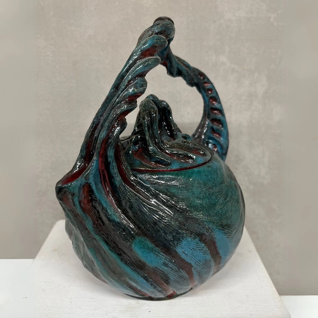 Théière en argile, tournée et déformée, avec des mailles rouges et bleues