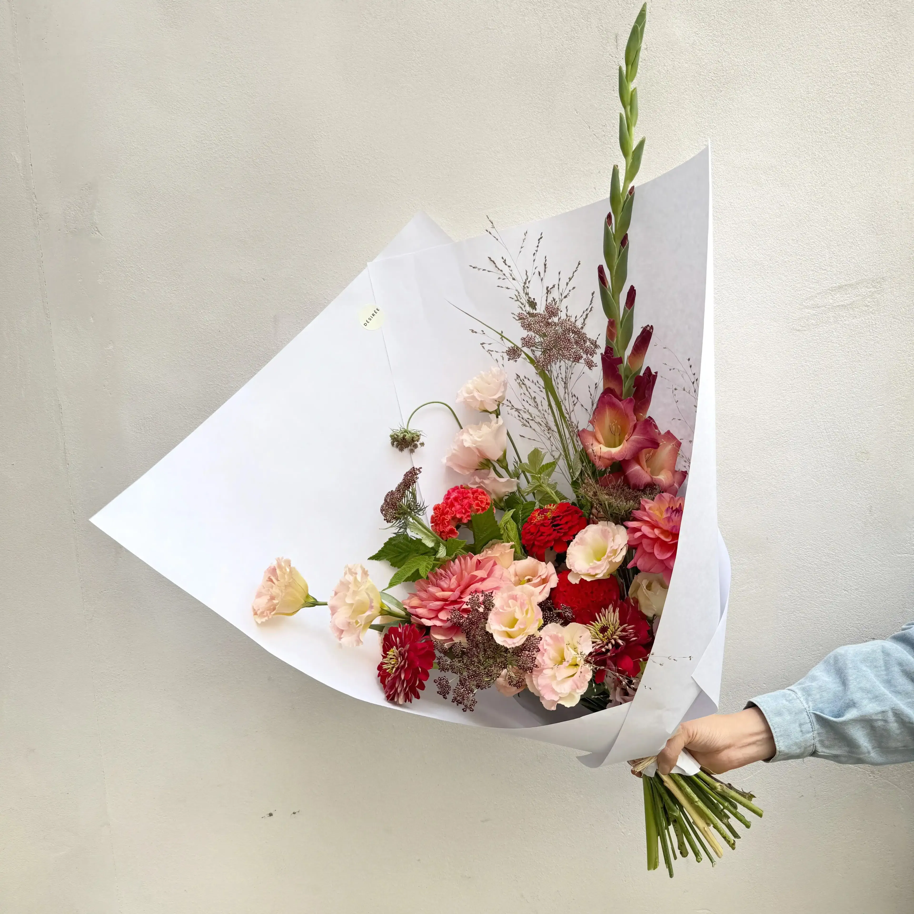 Pour le moment, Désirée livre exclusivement Paris intra-muros et la banlieue limitrophe. Les photos illustrent la taille "beaucoup". Les couleurs sont susceptibles de varier selon l'arrivage. Une livraison 100% garantie Une livraison aux petits oignons, ça ne s'improvise pas : chez Désirée, les destinataires sont systématiquement contactés (mais sans dire qu'ils vont recevoir un bouquet ni bien sûr de qui ça vient) pour nous assurer de leur présence et éviter les échecs de livraison. Vous avez une demande spécifique (couleurs, détails de livraison) ? Dites-nous tout dans le champ "commentaires" de la page panier ! Tous vos petits mots sont écrits à la main par de vrais humains, et nous mettons un point d'honneur à réaliser le bouquet de vos rêves en fonction des occasions ! Une brassée de fleurs de saison Pour célébrer l'arrivée de l'été, Désirée vous propose un bouquet composé d'un mélange de jolis lisianthus, d'île de France, de dahlias d'Ile de France, fleurs phares de la saison, agrémenté de fleurs champêtres et de feuillages odorants d'Ile de France. Cultivés entre juin et septembre dans le Var puis en Ile de France, nos fleurs sont issues d'exploitations visitées et sélectionnées pour leur approche raisonnable de la floriculture. Une envie de teintes en particulier ? Faites-nous en part au moment de la commande ! Un bouquet facile d'entretien Ce bouquet à l'excellente tenue en vase aura besoin de beaucoup d'eau. Pour prolonger leur durée de vie, installez vos fleurs dans une pièce fraiche ou même à l'extérieur pendant la nuit : vivifiées par la fraicheur, elle tiendront plus longtemps ! Une envie d'en savoir plus sur notre démarche ? Découvrez les engagements de Désirée, fleuriste écoresponsable !