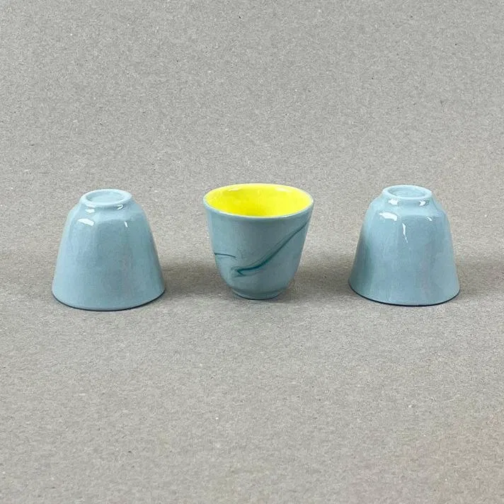 Porcelaine teintée dans la masse Pièces à colorations variables. 5 x4,5 cm 30 ML Se lever et débuter un moment qui ne devrait jamais se finir. Comme boire une tasse de café en regardant le soleil se lever sur la montagne et manger un oeuf coque en écoutant une douce musique pour accompagner cette contemplation. Ces petits coquetiers sauront vous séduire par leur délicatesse. Rien ne vous interdit d'y boire de la liqueur par ailleurs le soir. Nos objets sont obtenus par coulage, un à un, à la main. Ils présentent chacun des particularités qui attestent de leur aspect artisanal. Nous proposons des pièces à caractère unique, ou en petite série. C'est pourquoi le stock est limité.