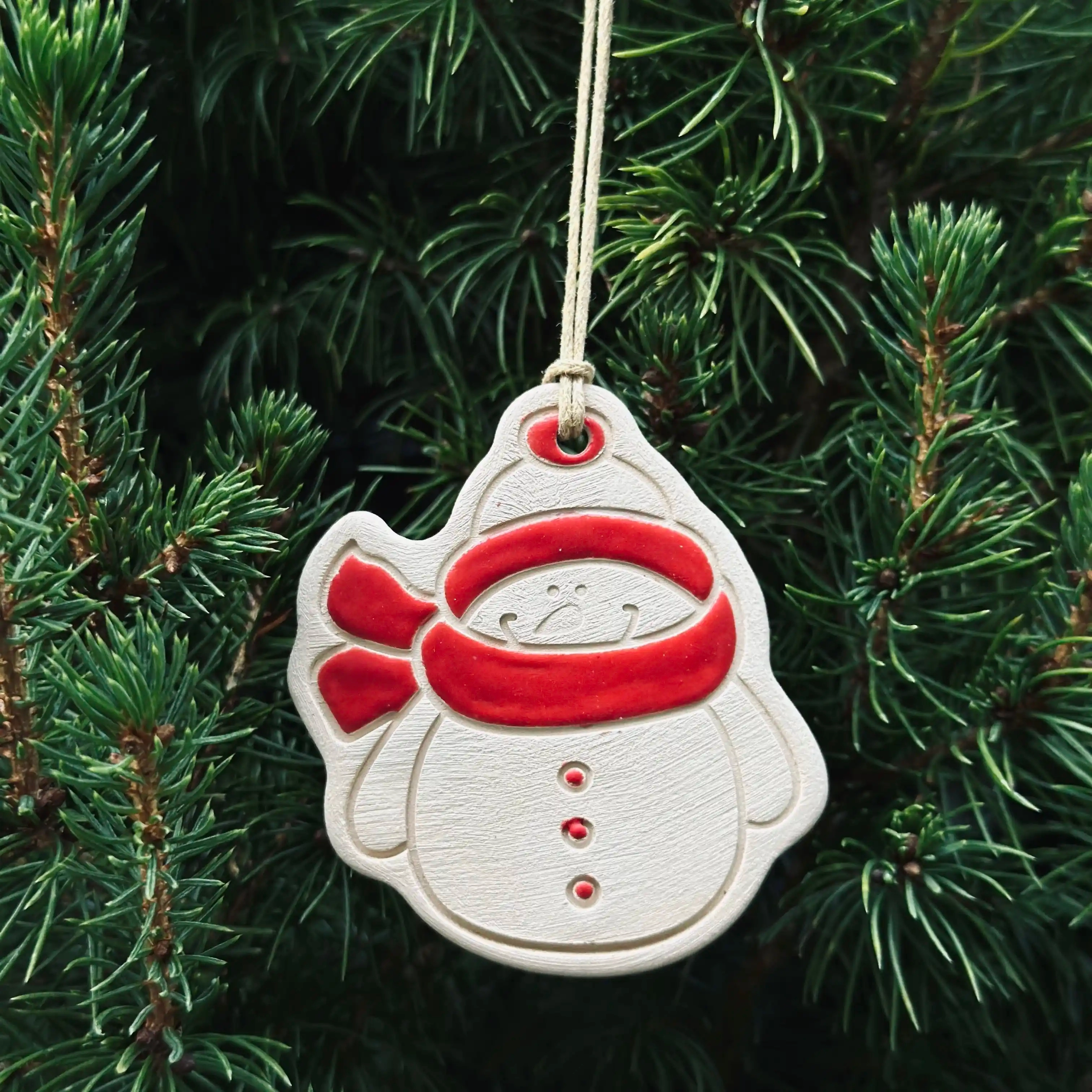 4 Pendentifs Bonhomme de neige pour sapin de Noël. Fabriqués à la main en faïence, à Paris. Environ 5x4,5 cm. Ficelle résistante en coton ciré. CAP Céramique Artisanale Parisienne