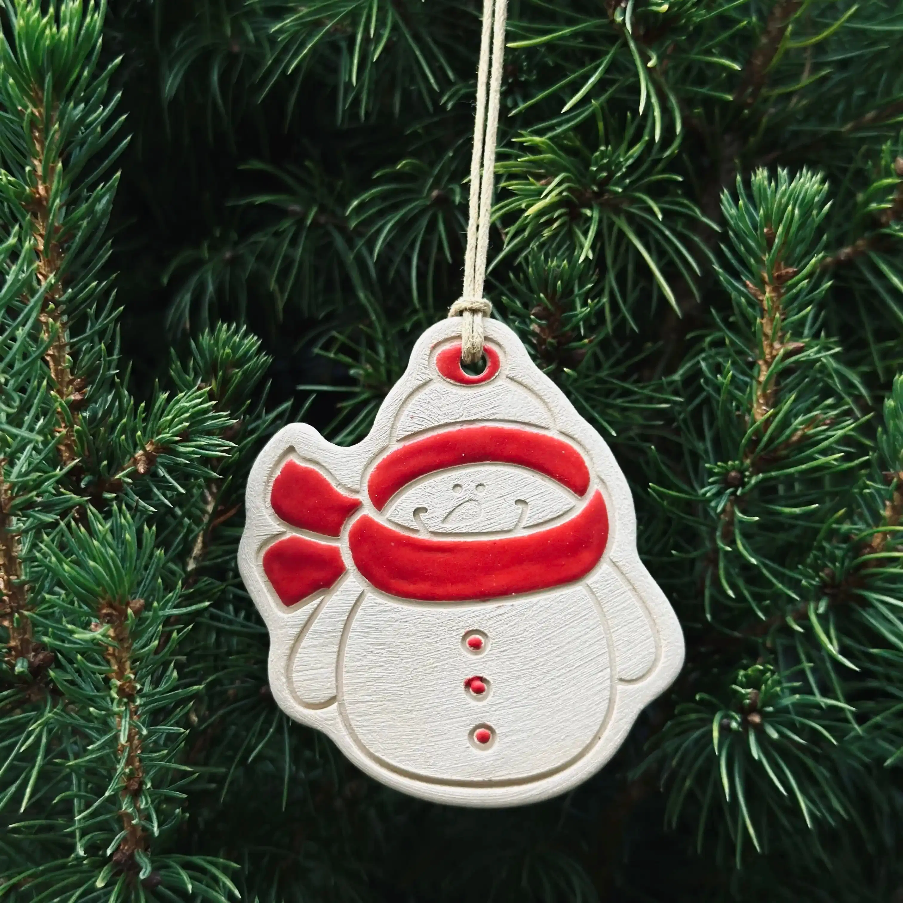 4 Pendentifs Bonhomme de neige pour sapin de Noël. Fabriqués à la main en faïence, à Paris. Environ 5x4,5 cm. Ficelle résistante en coton ciré. CAP Céramique Artisanale Parisienne