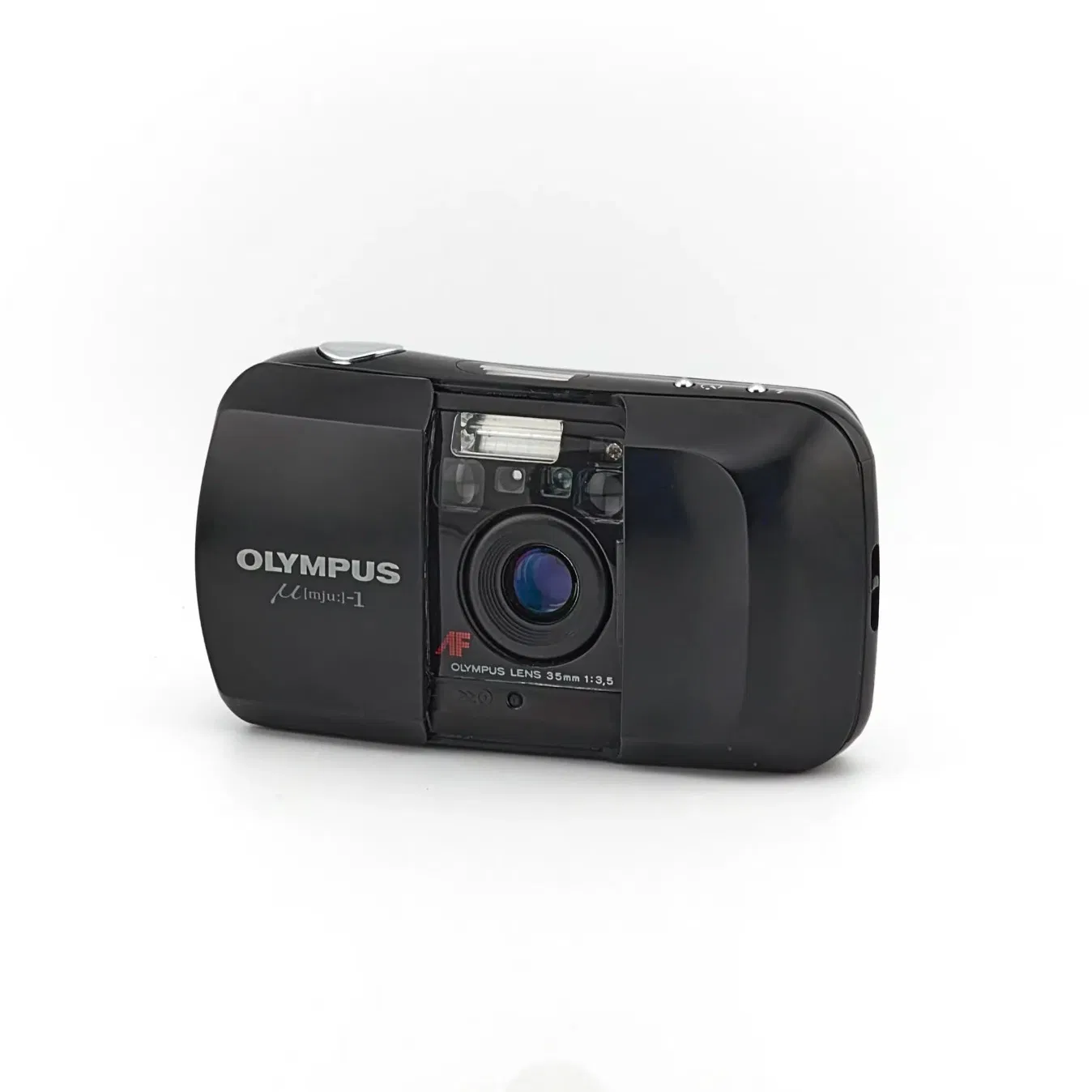 Petit compact 35 mm : discrétion et facilité en argentique.
L’Olympus mju I est un compact argentique léger et étanche, sorti en 1991. Son objectif 35 mm fixe et son autofocus actif le rendent simple à utiliser. Léger et discret, il permet de capturer des souvenirs dès le premier rouleau, sans réglages compliqués.