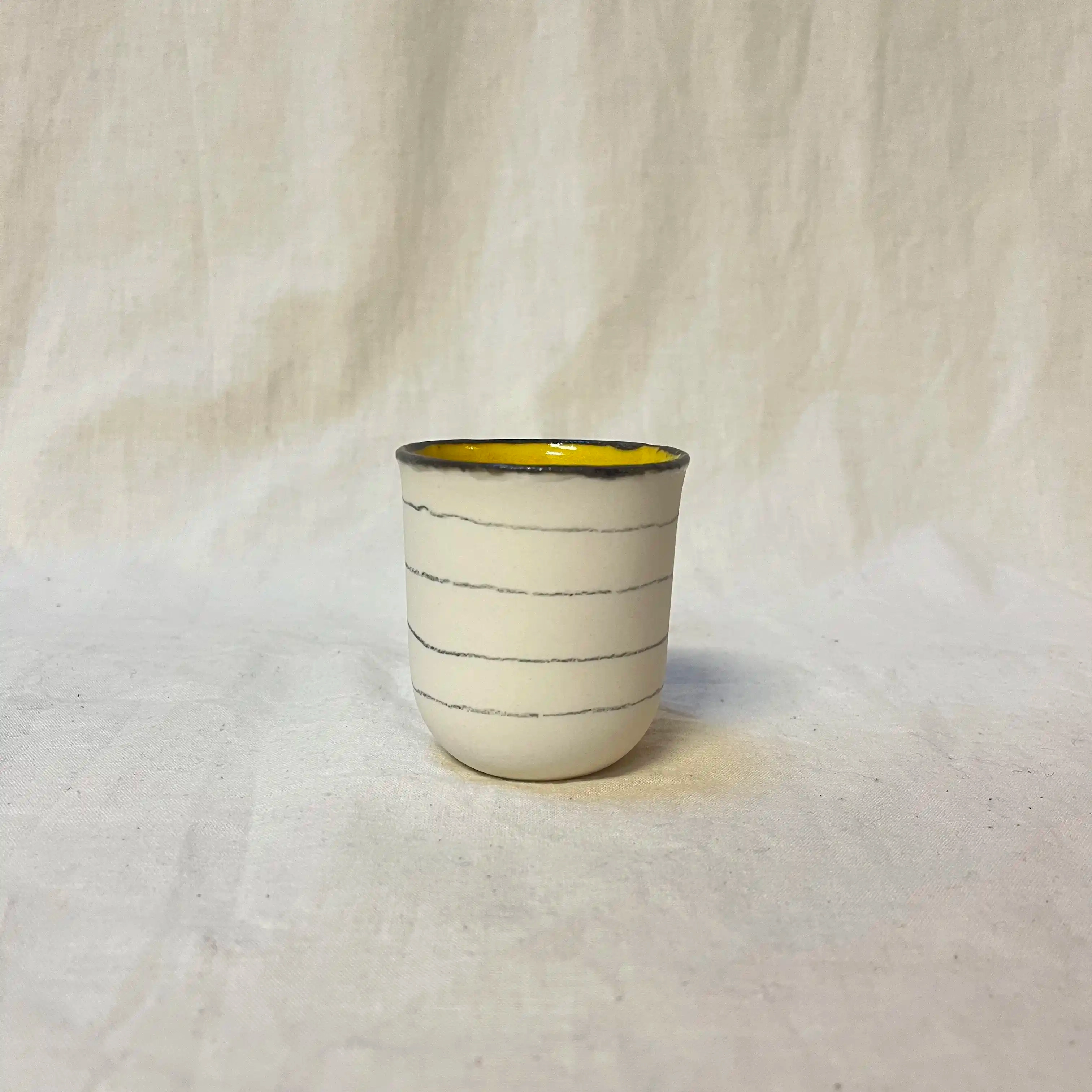 Tasse porcelaine moulée. Diamètre 6,5cm, hauteur 7 cm. Émail intérieur, décor au crayon à oxydes