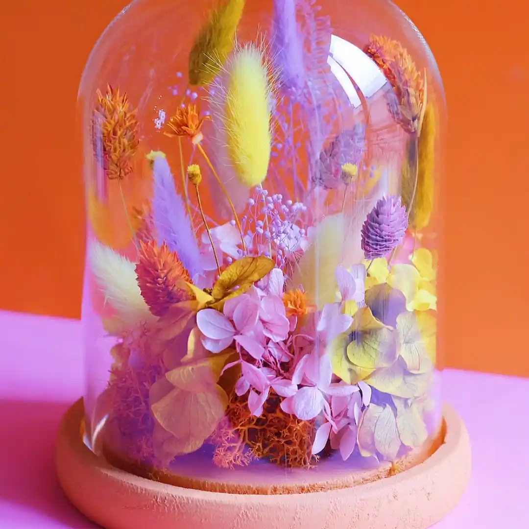 Moyenne cloche de fleurs séchées
Dimensions : ø 14 cm x H 17 cm
Rose, orange, jaune avec un socle orange peint à la main