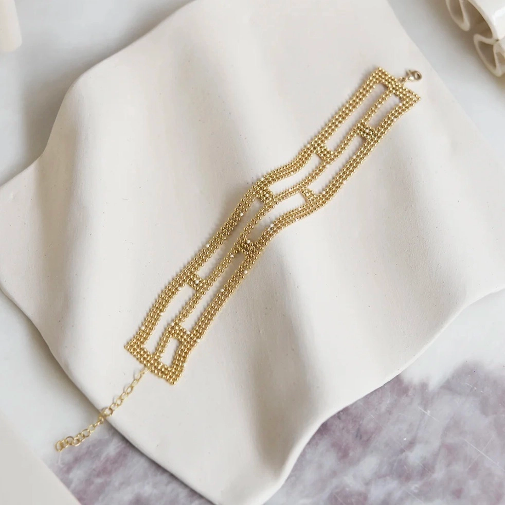 La ligne Tapestry s’inspire des tapisseries anciennes et des broderies précieuses. Elle rend hommage au travail minutieux et au temps long, avec des pièces ouvragées mais toujours épurées. Un jeu de composition minimal ayant pour point de départ une même trame de perles fines, travaillées comme de petites architectures tantôt géométriques, tantôt organiques. Des pièces subtiles qui captent la lumière.
Matériaux : en laiton doré à l'or fin recyclé 24 carats, couleur laquée
Dimensions : longueur 15,5 cm + chaînette de réglage
Poids : 8,5g
Tous nos bijoux sont garantis 2 ans
Pensé et fabriqué main à Paris
Livré dans son packaging individuel écologique.
Conseils d'entretien : évitez le contact avec l'eau et le parfum afin que le bijou conserve son éclat
Nos matières premières sont soigneusement sélectionnées et sans risques pour votre santé : elles ne contiennent ni plomb, ni nickel, ni cadmium, conformément à la législation.