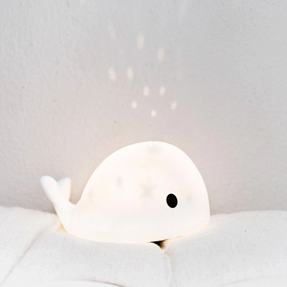 Projecteur en forme de baleine Moby, qui peut faire office de veilleuse. Un motif étoilé se projette au plafond
