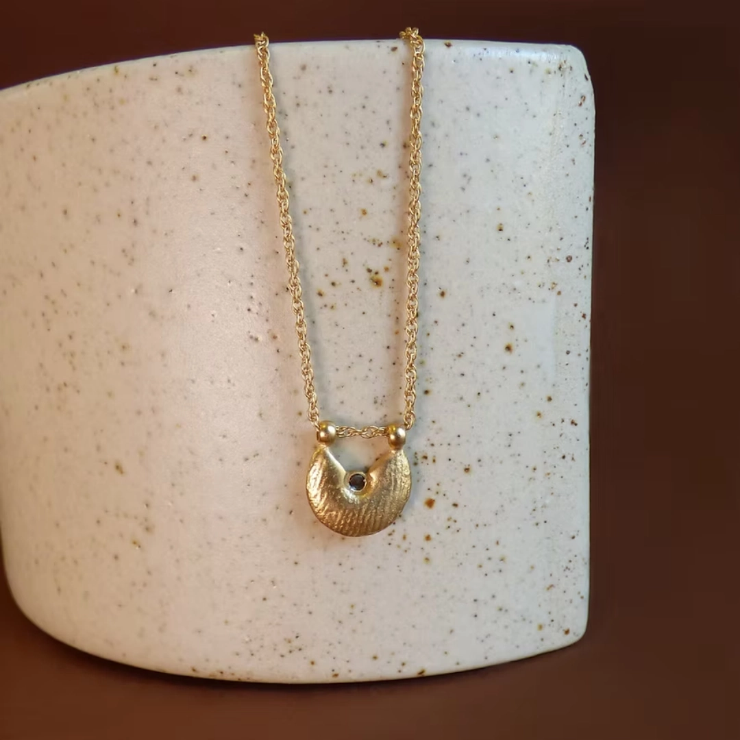 Le collier NUBIA est une chaîne torsadée sur laquelle repose une médaille irrégulière au fini satiné. Ce pendentif a été fabriqué à partir de perles de métal africaines, dont la texture varie d'une pièce à l'autre, puis agrémenté d'une petite pierre.
Les bijoux Atelier Nicol sont entièrement fabriqués en laiton (sans nickel, non allergène), puis recouverts d'un bain d'or. Le placage trois microns permet à chaque pièce de pouvoir vous accompagner au quotidien et de durer dans le temps. Les bijoux plaqué argent sont, quant à eux, recouvert d'un bain d'argent de dix microns.