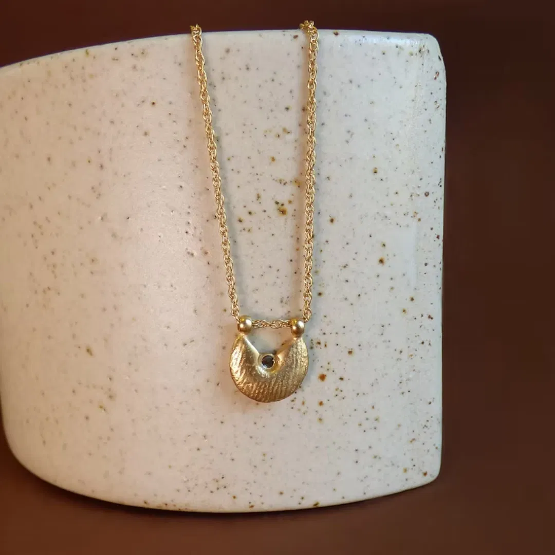 Le collier NUBIA est une chaîne torsadée sur laquelle repose une médaille irrégulière au fini satiné. Ce pendentif a été fabriqué à partir de perles de métal africaines, dont la texture varie d'une pièce à l'autre, puis agrémenté d'une petite pierre.
Les bijoux Atelier Nicol sont entièrement fabriqués en laiton (sans nickel, non allergène), puis recouverts d'un bain d'or. Le placage trois microns permet à chaque pièce de pouvoir vous accompagner au quotidien et de durer dans le temps. Les bijoux plaqué argent sont, quant à eux, recouvert d'un bain d'argent de dix microns.