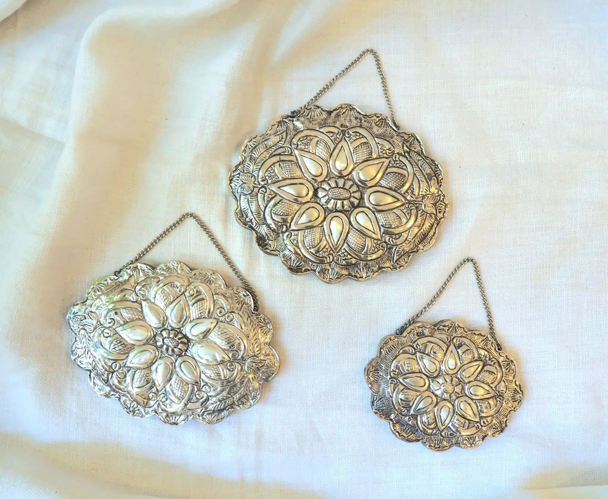 Miroir mural Ottoman ancien en argent 900 fabriqué à la main en Turquie dans les années 1900. Nous vous le proposons en trois tailles différentes
Dimensions :
Taille L 16 x 13 cm, Taille M 15 x 11, Taille S 11 x 9 cm
Ces miroirs précieux en argent font traditionnellement partie des objets que possédaient les femmes lors de leur mariage.
Ils disposent d’une chaîne afin de pouvoir l’accrocher facilement au mur. Retournez les lorsque vous ne les utilisez pas afin de profiter du travail élégant réalisé à l’arrière. Le dos est en effet finement ciselé de jolis motifs en relief, qui font de chacun une pièce unique et une véritable oeuvre d’art.
Nous avons chiné pour vous ces trois miroirs Ottomans anciens en argent chez un brocanteur à Athènes en Grèce. Magnifiquement travaillés, vous apprécierez les détails tout en relief de chaque pièce et pourrez les disposer seuls ou en accumulation, et pourquoi pas dans un pêle mêle mural, parmi d’autres objets décoratifs. C’est un accessoire à la fois fonctionnel et stylisé, qui apportera une touche de poésie à votre intérieur.
Nous ne fournissons pas le clou nécessaire à sa suspension.
Cette pièce apportera caractère et authenticité à votre décoration d’intérieur, pour un style unique. Ajoutez une touche élégante et vintage à votre maison en adoptant cet ancien miroir Ottoman en argent, qui ira dans toutes les pièces de votre intérieur!
On estime ces miroirs au début du XXème siècle
Veuillez noter qu’aucune pièce n’est parfaite. Ces objets sont anciens et ont été utilisés, ils comportent donc pour certains des traces d’usure normale. Ces imperfections font partie du charme de ces objets anciens, nous ne les considérerons donc pas comme des défauts. Ils leur apportent au contraire tout leur caractère.