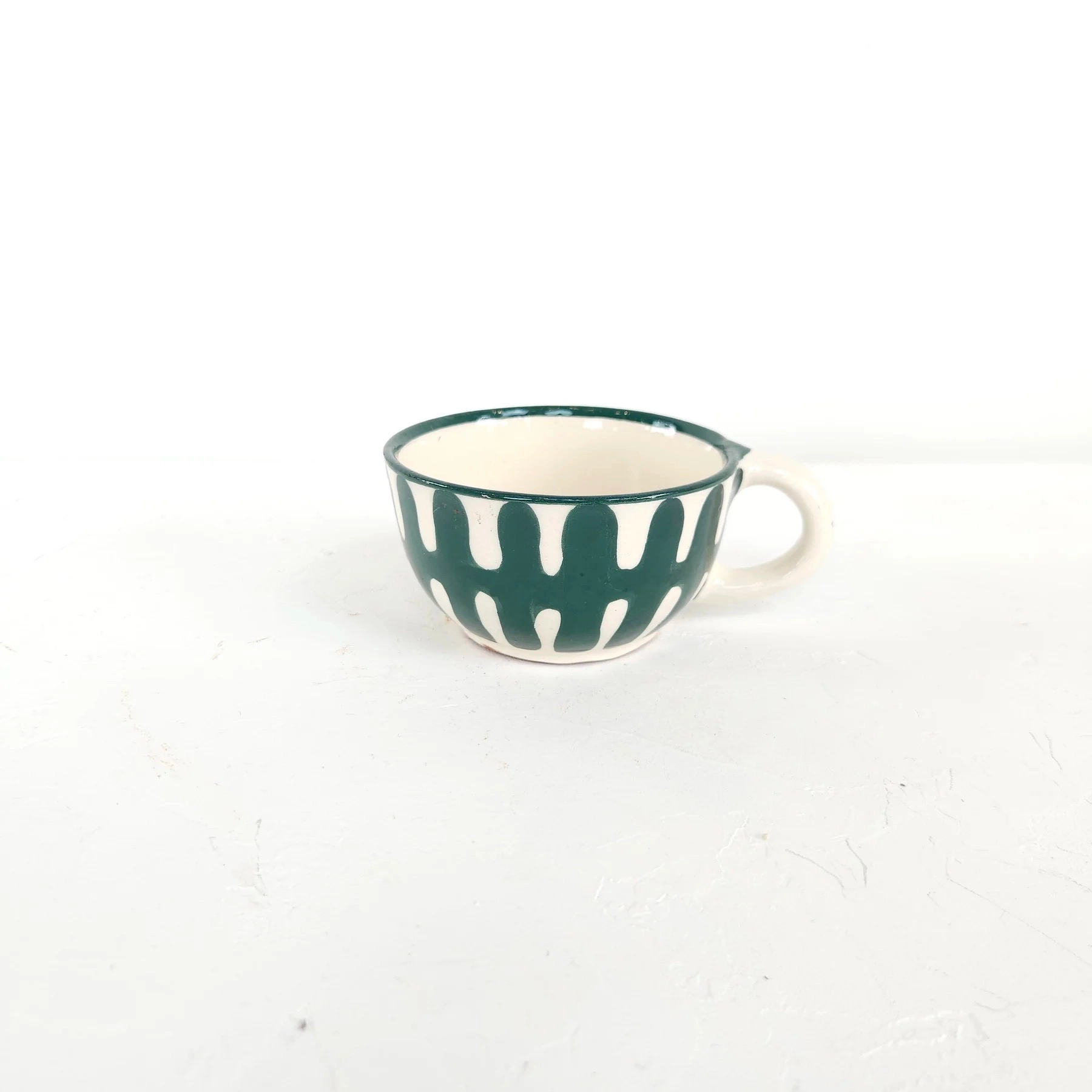 Chaque pièce est tournée à la main par notre potier, puis enduite d'un engobe (émail blanc) avant d'être décorée à main levée de nos motifs uniques, puis émaillée et cuite une seconde fois afin de révéler la profondeur des couleurs.
Chaque dessin est pensé pour s'associer aux autres motifs. Tous nos motifs sont imaginés et créés par et pour M3TISS et réalisés exclusivement pour la marque.
Verte Canard. Diamètre 5,5 cm / Hauteur 6 cm