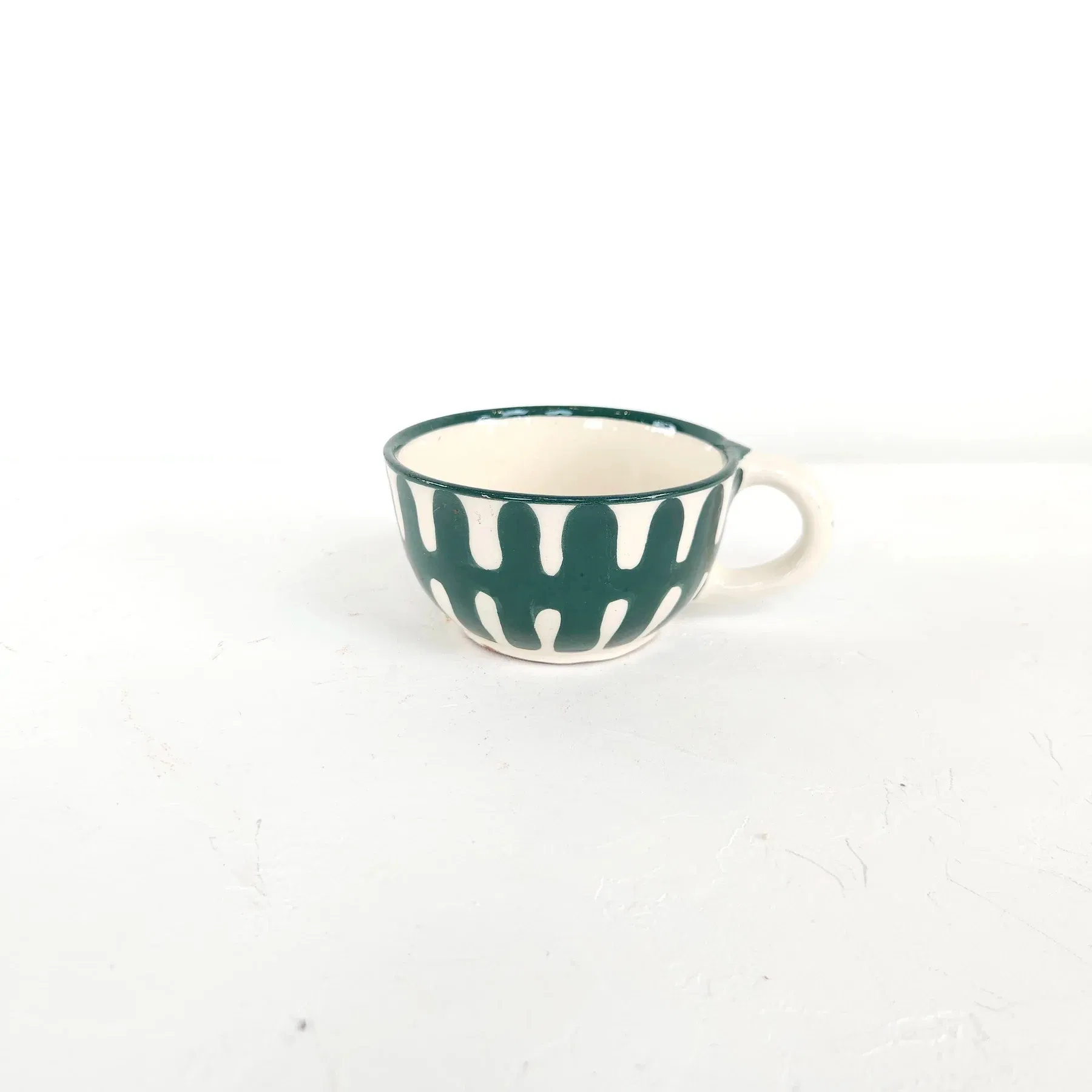 Chaque pièce est tournée à la main par notre potier, puis enduite d'un engobe (émail blanc) avant d'être décorée à main levée de nos motifs uniques, puis émaillée et cuite une seconde fois afin de révéler la profondeur des couleurs.
Chaque dessin est pensé pour s'associer aux autres motifs. Tous nos motifs sont imaginés et créés par et pour M3TISS et réalisés exclusivement pour la marque.
Verte Canard. Diamètre 5,5 cm / Hauteur 6 cm