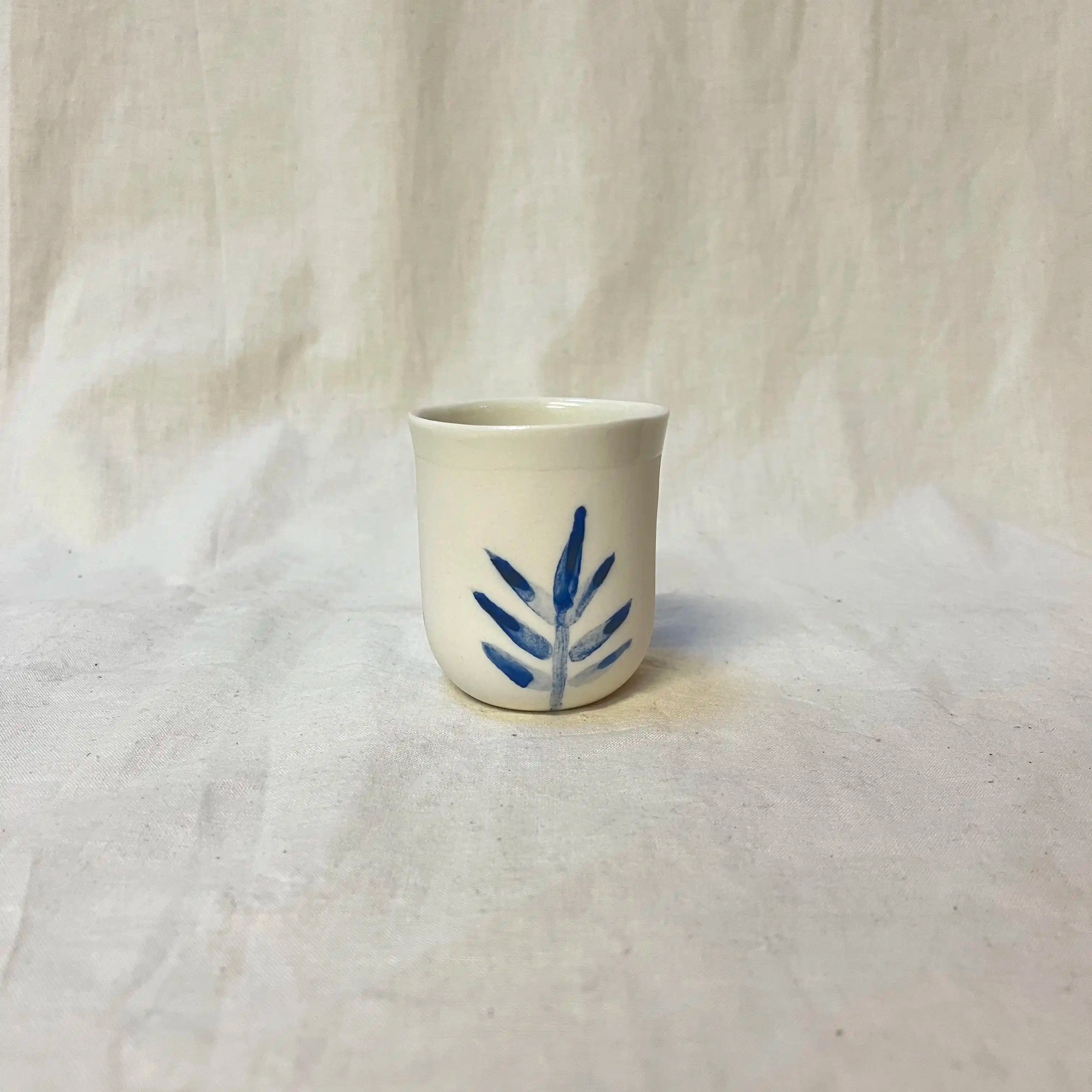 Tasse porcelaine moulée. Diamètre 6,5cm, hauteur 7 cm. Émail intérieur, décor au jus d’oxydes