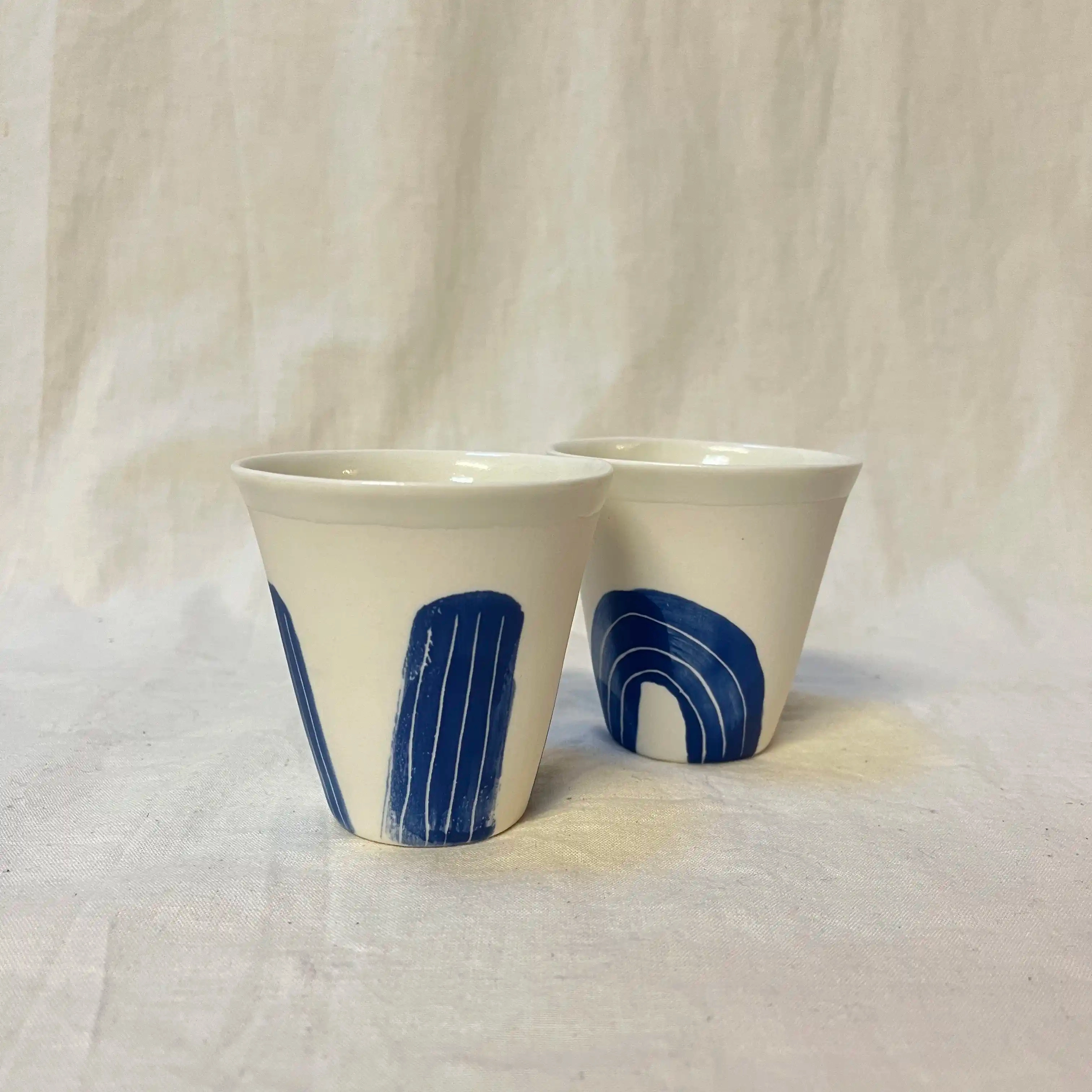 Tasse en porcelaine moulée. Diamètre 8 cm, hauteur 8,5cm. Décors à l’engobe